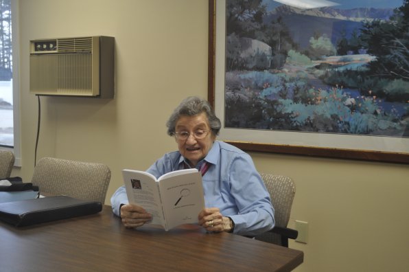 Mara Clark leafing through her new book Dee Evans: Special Agent, A Woman Addicted to Danger.