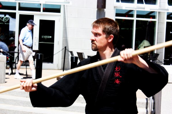 Ian Evans wields his staff while warming up for a martial arts display.
