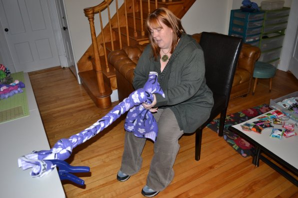 Kim Beers uses her super human strength to braid the final part of a colossal dog toy in her workshop at home.
