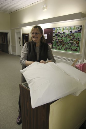 Terry Blake, co-director of the Concord Cold Weather Shelter, dresses a pillow at the shelter last week.