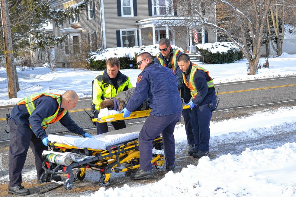 The Station 4 engine and ambulance crew load a patient on to the stretcher after a fall and subsequent ankle injury for transport to Concord Hospital. (TIM GOODWIN / Insider staff) -