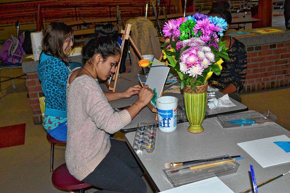 Sophomore Sapana Darjee gets going on a painting in Canvas and Cookies. (TIM GOODWIN / Insider staff) -