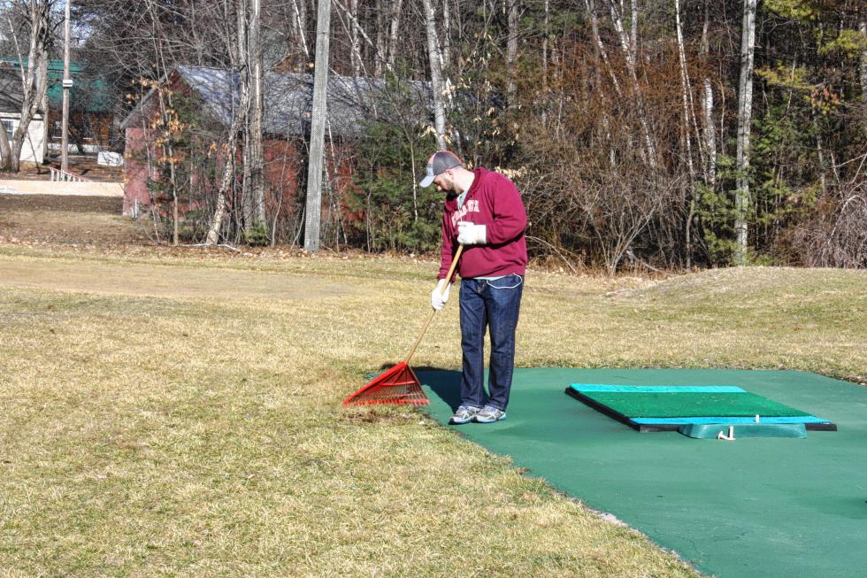 Corey Luckern rakes up the area surrounding the driving range at Beaver Meadow Golf Course. (JON BODELL / Insider staff) -
