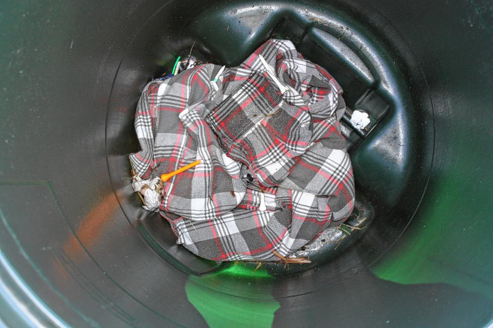 The casualties of cleanup: a shirt and at least one golf tee that were left around the driving range were tossed into the circular file. That's what happens when you leave your stuff around! (JON BODELL / Insider staff) -