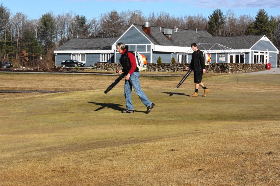 Terry Anderson (left) and Alex Bashios use leaf-blowers to clear off a green at Beaver Meadow Golf Course last Wednesday. The crew was getting ready for Beaver Meadow to open the next day – the earliest opening date in Beaver Meadow's long, long history. (JON BODELL / Insider staff) -