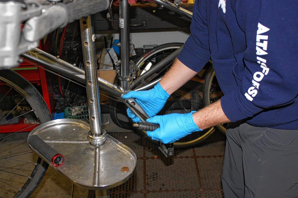 Finn Westbrook works on the crank of a customer's bike at S&W Sports. (JON BODELL / Insider staff) -