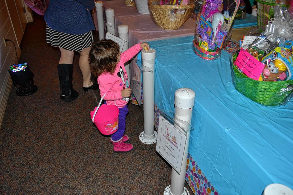 Elianna Murillo, 2, drops in a ticket for the basket she was hoping to win. (TIM GOODWIN / Insider staff) -