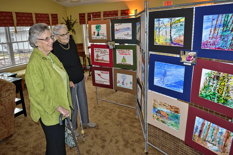 Jane Hurst (left) and Grace Stetson admire the work at Thursday’s Art From the Heart reception. (TIM GOODWIN / Insider staff) -
