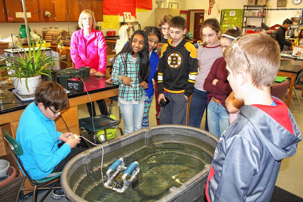 From left: Jacob Scavarelli, adult volunteer Susan, Hemanta Darjee, Pramika Darjee, Nick Richards, Alex Reynolds, Jessie Willey, Kristin Womack and Nolan Cloutier gather around a tub while Jacob controls his robot. He made this one a couple summers ago, but it's very similar to what was being built in the classroom. (JON BODELL / Insider staff) -