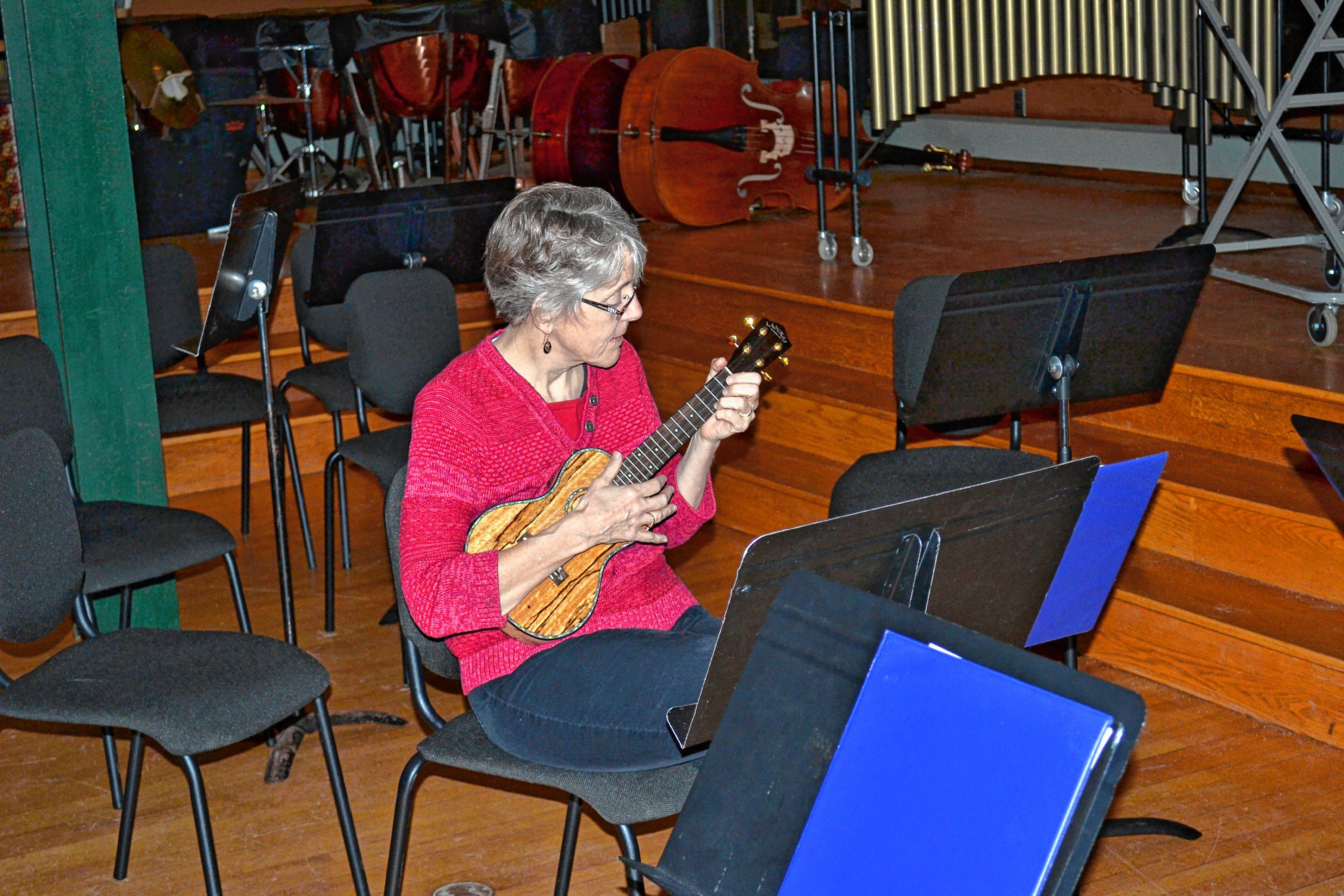 Left: Debbie Potter, left, helps Callie Burhart, a St. Paul’s student, learn a few chords. Above: Susanne Kibler-Hacker strums away.