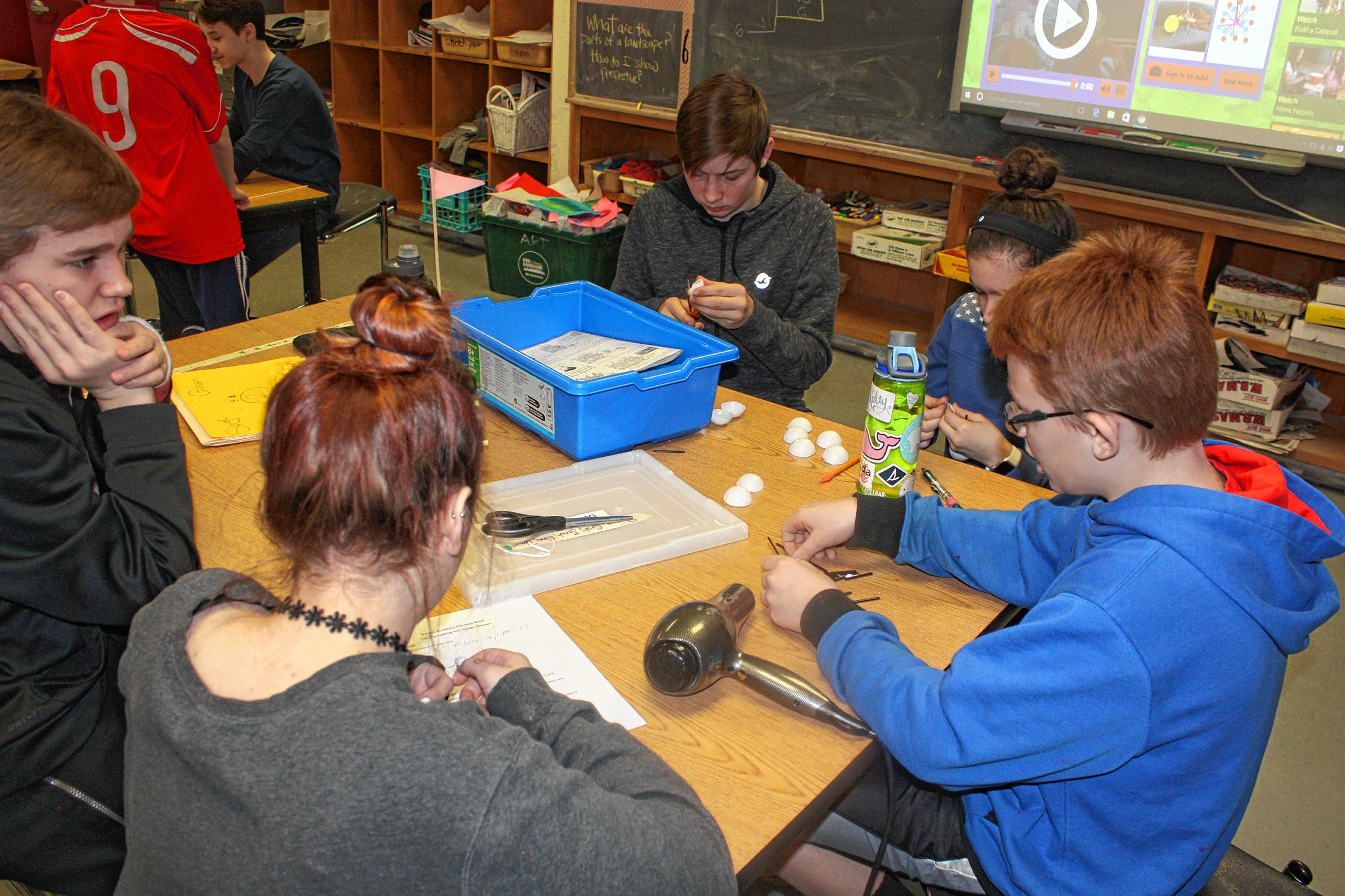 From left: Students Giovanni Carone, Saige Reed, Damien McRae, Emma Fleischman and Jonah Wachter work together on their Strandbeest project at Rundlett Middle School last week. Everybody had a different job all working toward the same goal, letting each student put his or her skills to use in the best way.(JON BODELL / Insider staff)