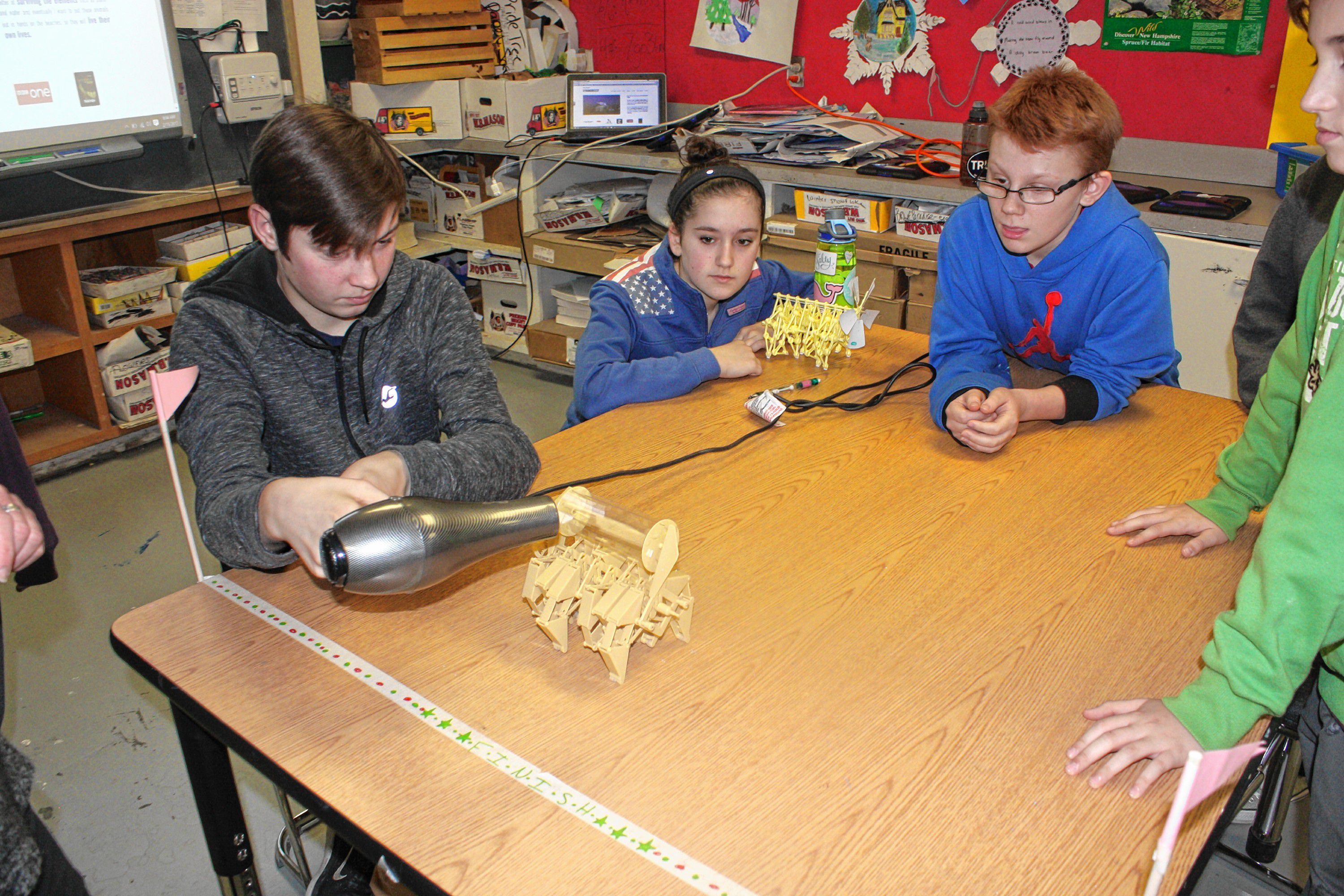 Students Jonah Wachter (left), Emma Fleischman and Damien McRae (right) check out a different Strandbeest model, this one a rhinoceros. There are two models of Strandbeest currently available for sale, and the eighth-grade art classes have all been working on the same one, called Animaris Ordis Parvus.(JON BODELL / Insider staff)