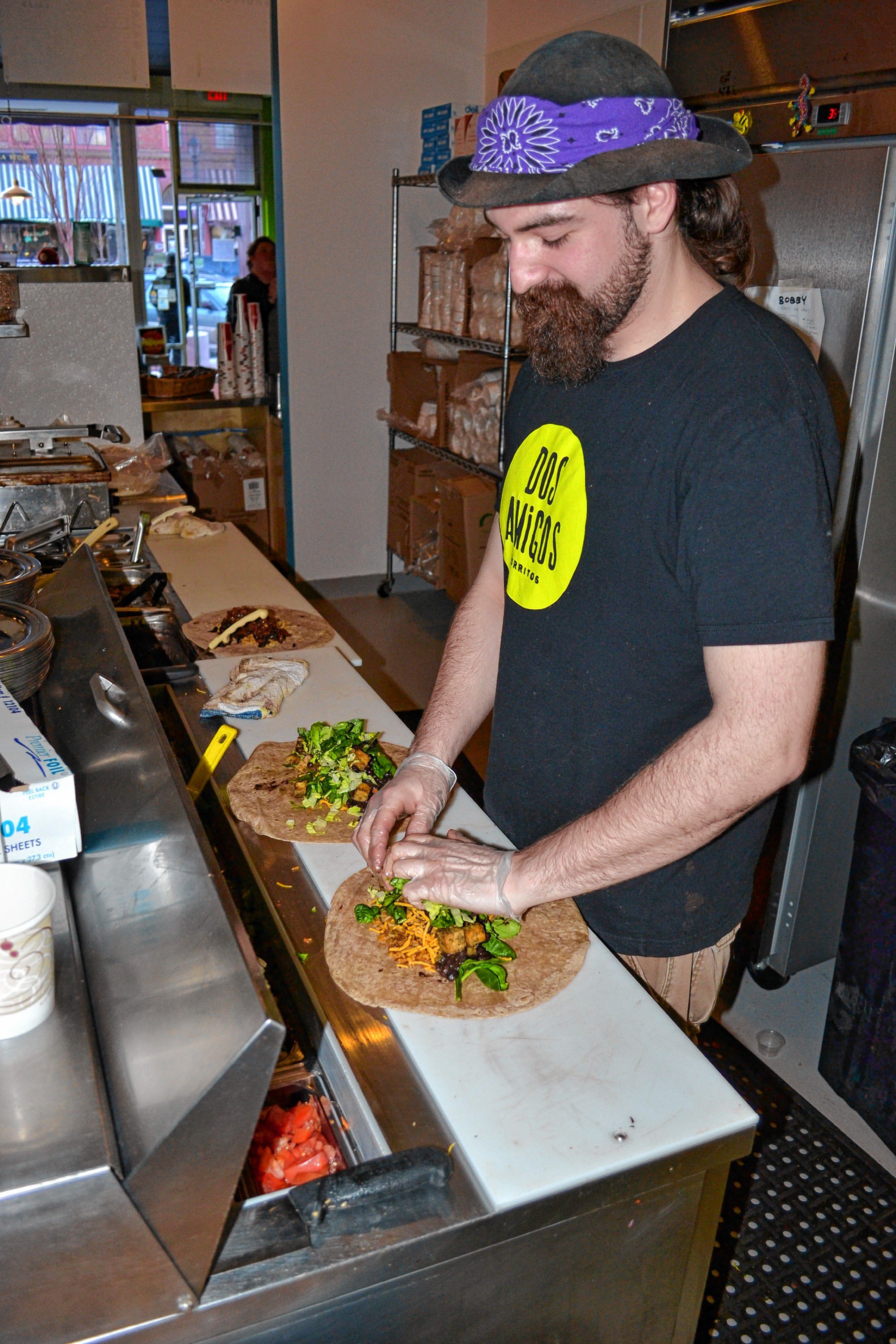 Hank Bernstein, aka Captain Sunshine, makes a couple tasty looking burritos last week at Dos Amigos.