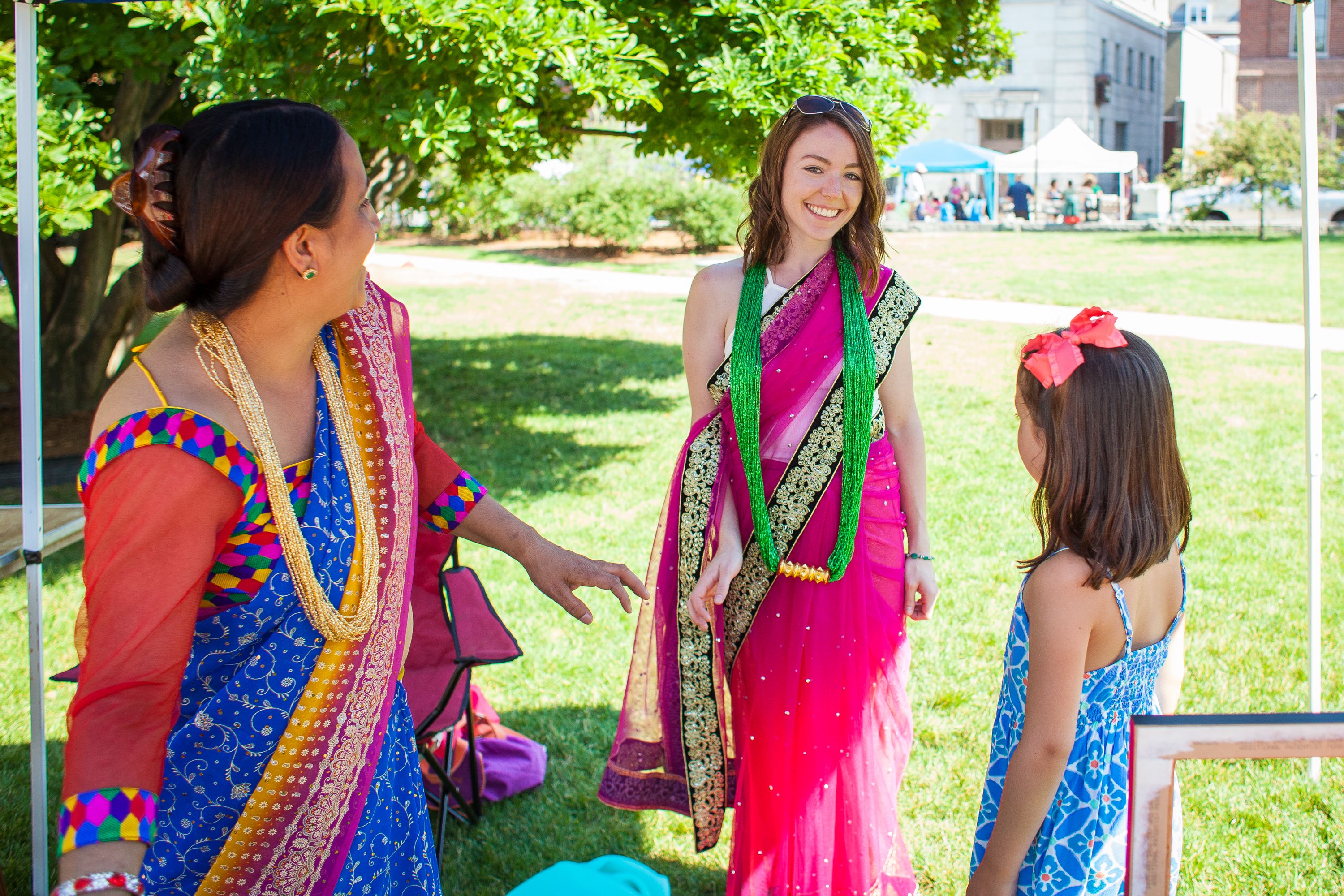 Corrin Foley (center) of Goffstown tries on a saari with the help of Nar Sharma (left) during the Concord Multicultural Festival downtown on Saturday, June 25, 2016. Sharma had a variety of garments from across South Asia for visitors to try on. (ELIZABETH FRANTZ / Monitor staff) Elizabeth Frantz