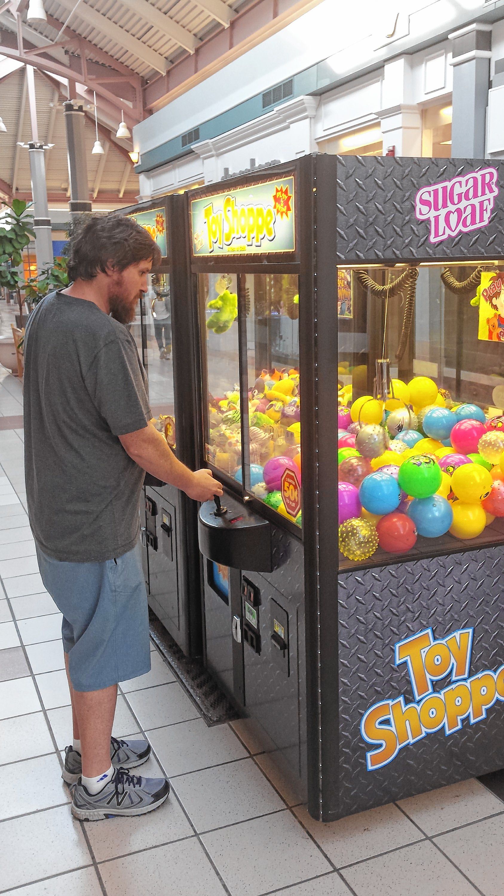 Tim lines up the claw with one of the many fabulous prizes at one of the claw machines at Steeplegate Mall last week. Despite his patience and concentration, he came up empty-clawed. JON BODELL / Insider staff