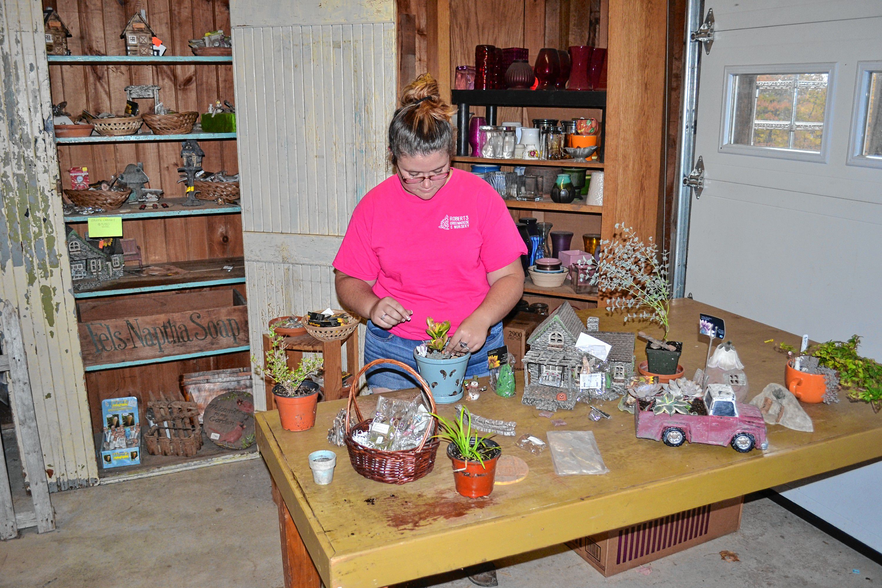 Kelsey Lorden puts the finishing touches on a fairy garden at Roberts Greenhouse. TIM GOODWIN / Insider staff