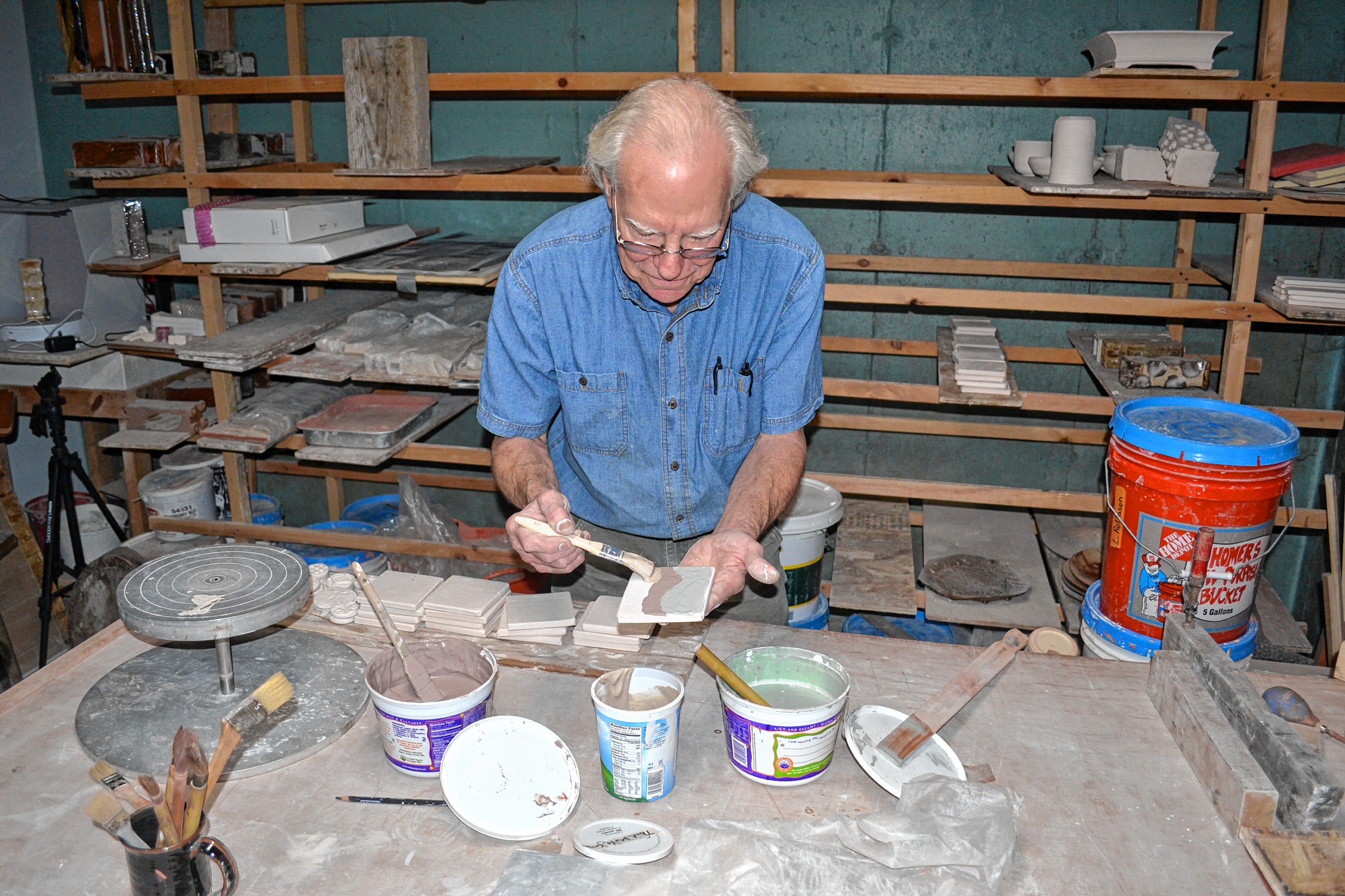 Andy Hampton of Hampton pottery paints tiles, a hands on craft he will offer at his home studio during N.H. Open Doors. TIM GOODWIN / Insider staff