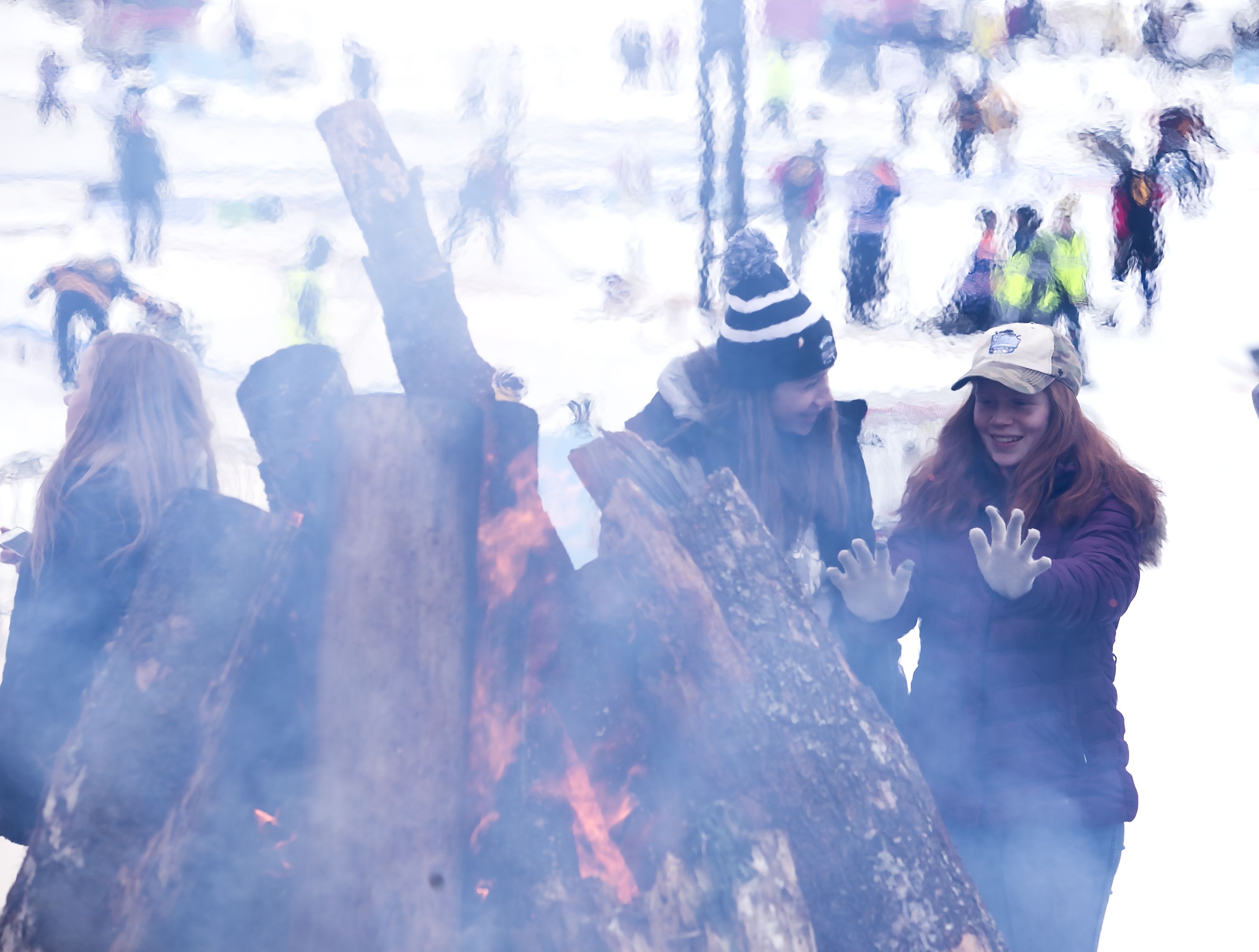 Concord High School freshman Casey Ingrahan, right, keeps warm by the bonfire with her friend Abby Sawyer at the Black Ice tournament Saturday.  GEOFF FORESTER