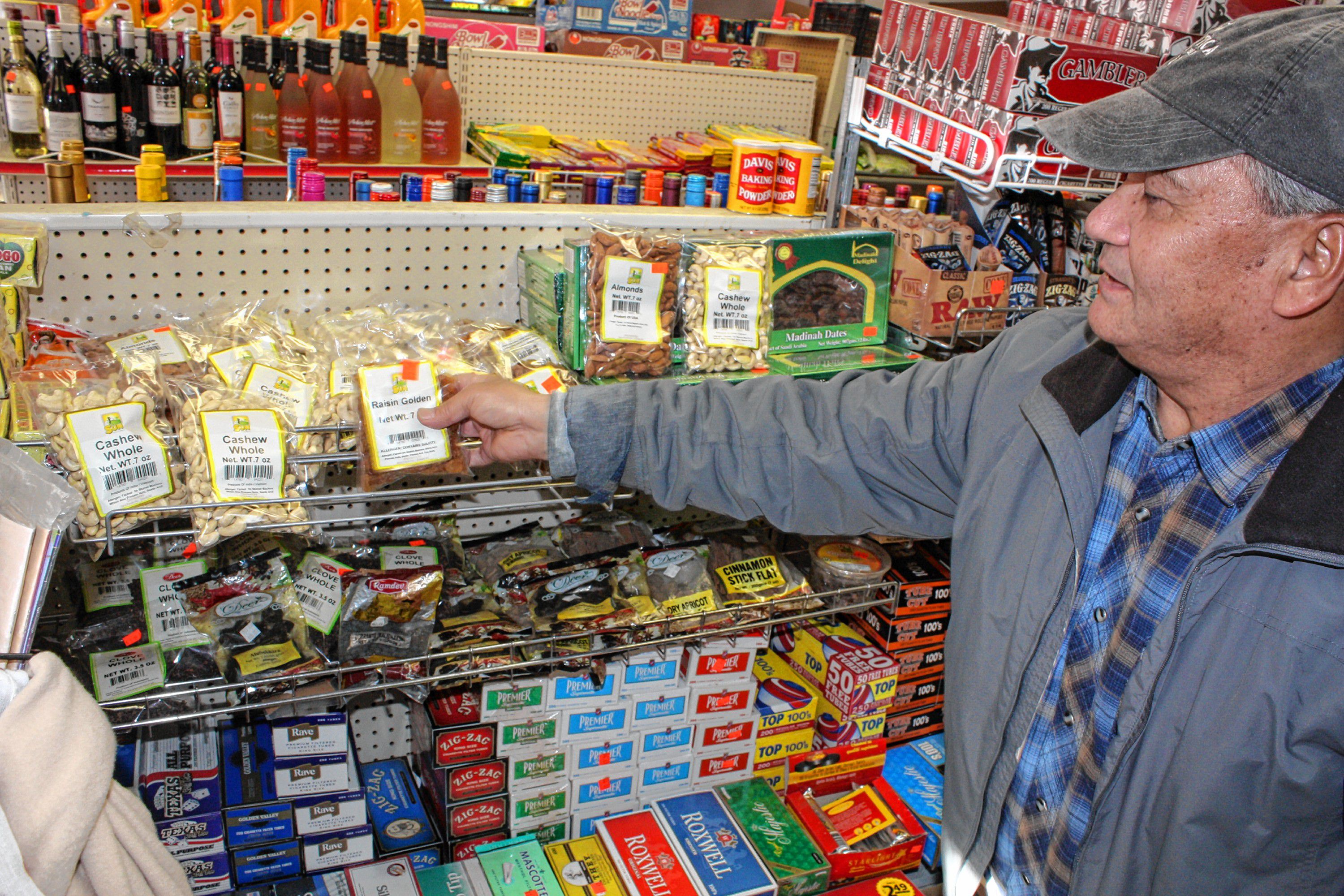 Dhruba Shrestha, owner of the international grocery store Concord Mart on North Main Street, points out some of the items at his store that are more popular among American customers -- nuts, raisins,  dates and cloves, mostly. JON BODELL / Insider staff