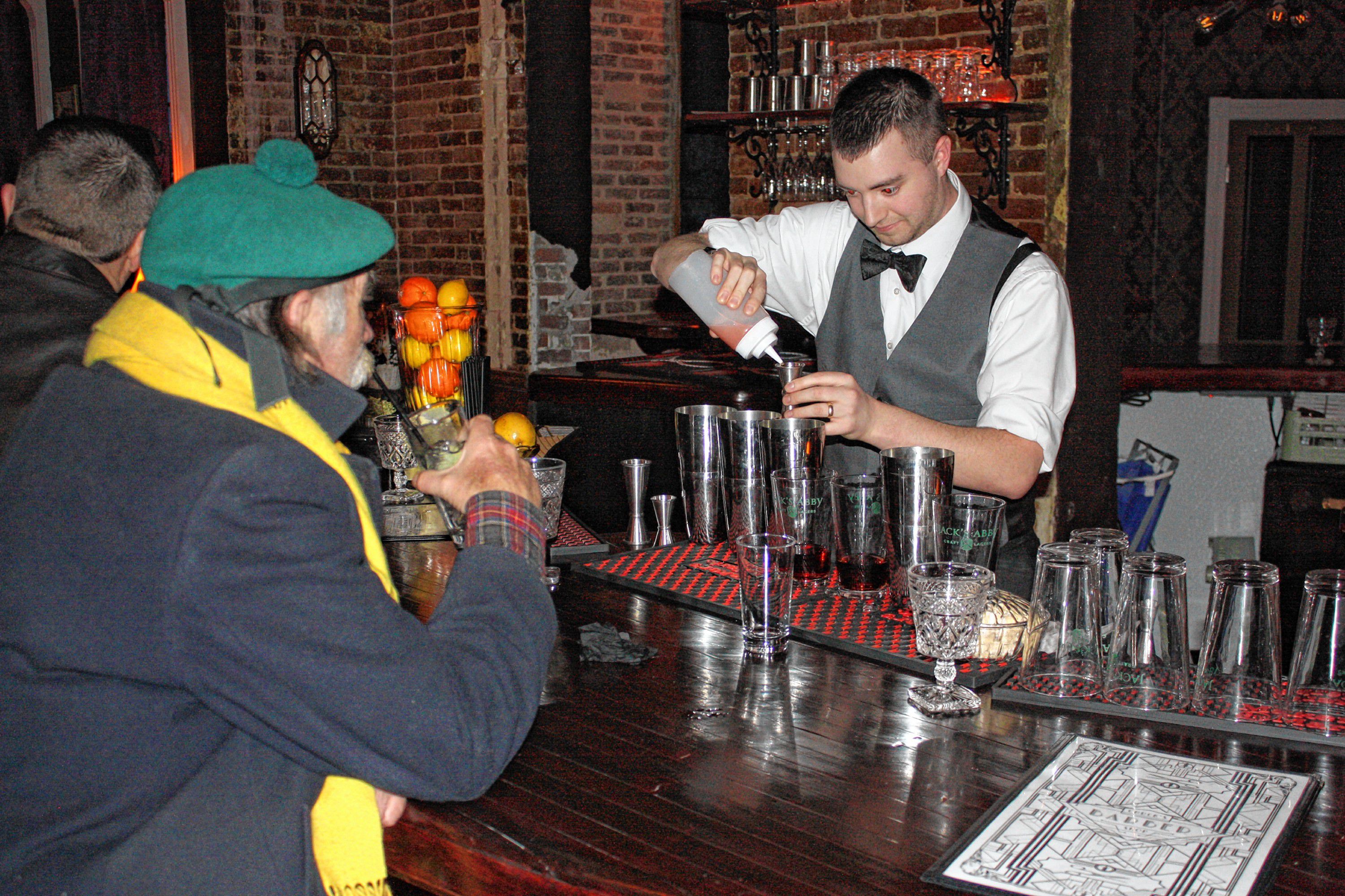 Bartender James Murray prepares a cocktail on opening night of Chuck's Barbershop in Eagle Square last Tuesday. JON BODELL / Insider staff