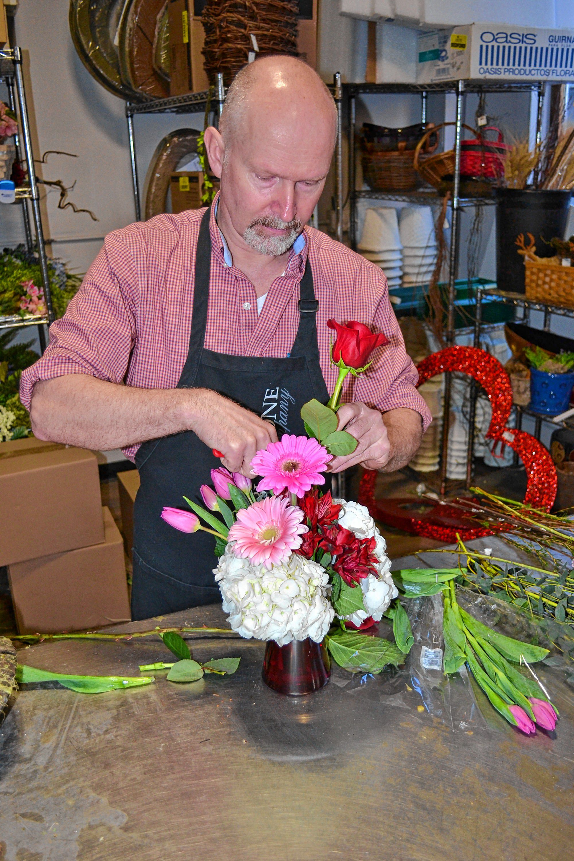 Brad Towne, owner of Cobblestone Design, puts together an arrangement of fresh flowers in preparation for Valentine's Day. TIM GOODWIN / Insider staff