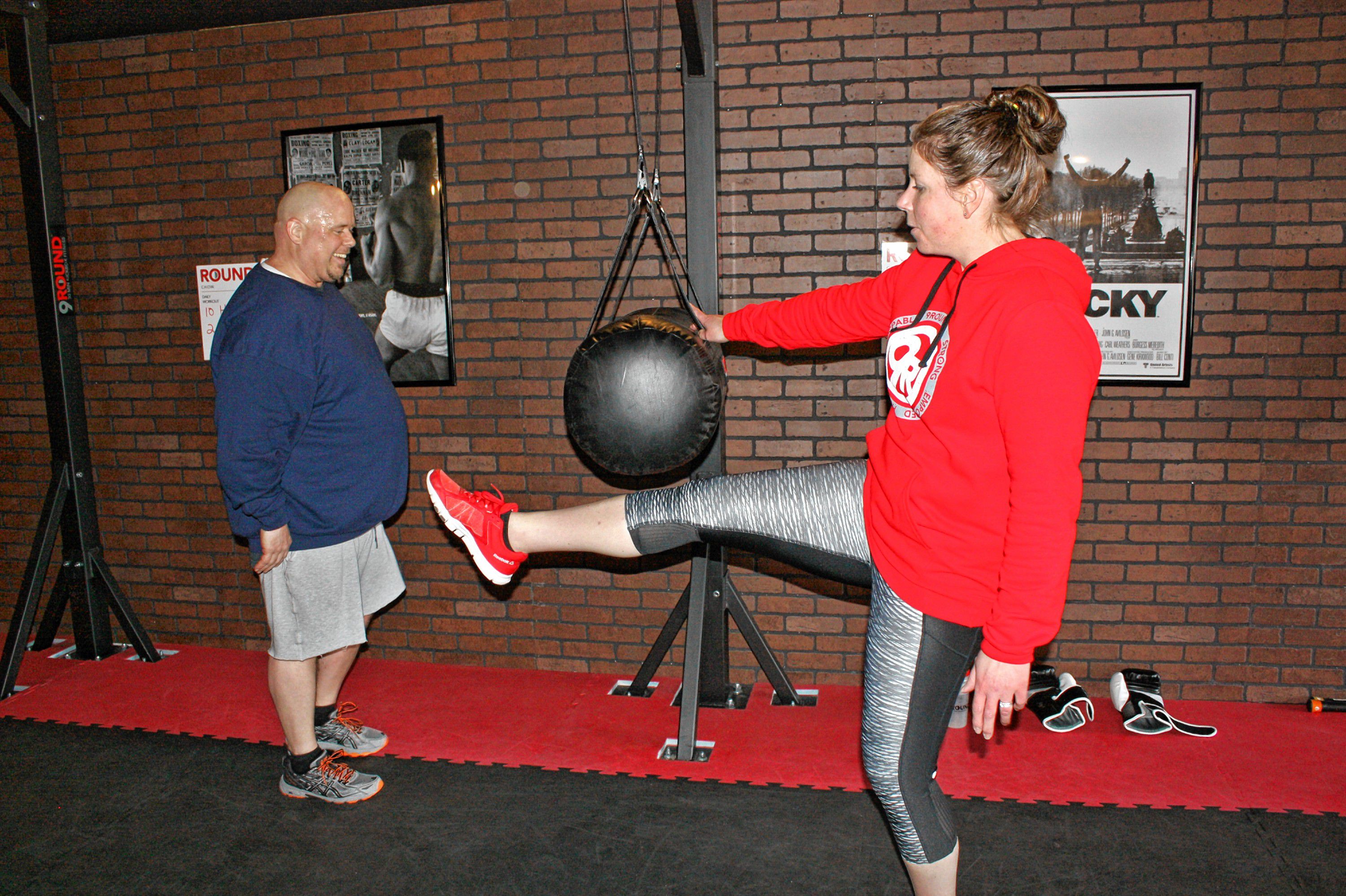 9Round owner Laurie Weingartner works with Les Reed on a kicking workout at 9Round, the new kickboxing-style gym on Ford Eddy Road, last week. JON BODELL / Insider staff