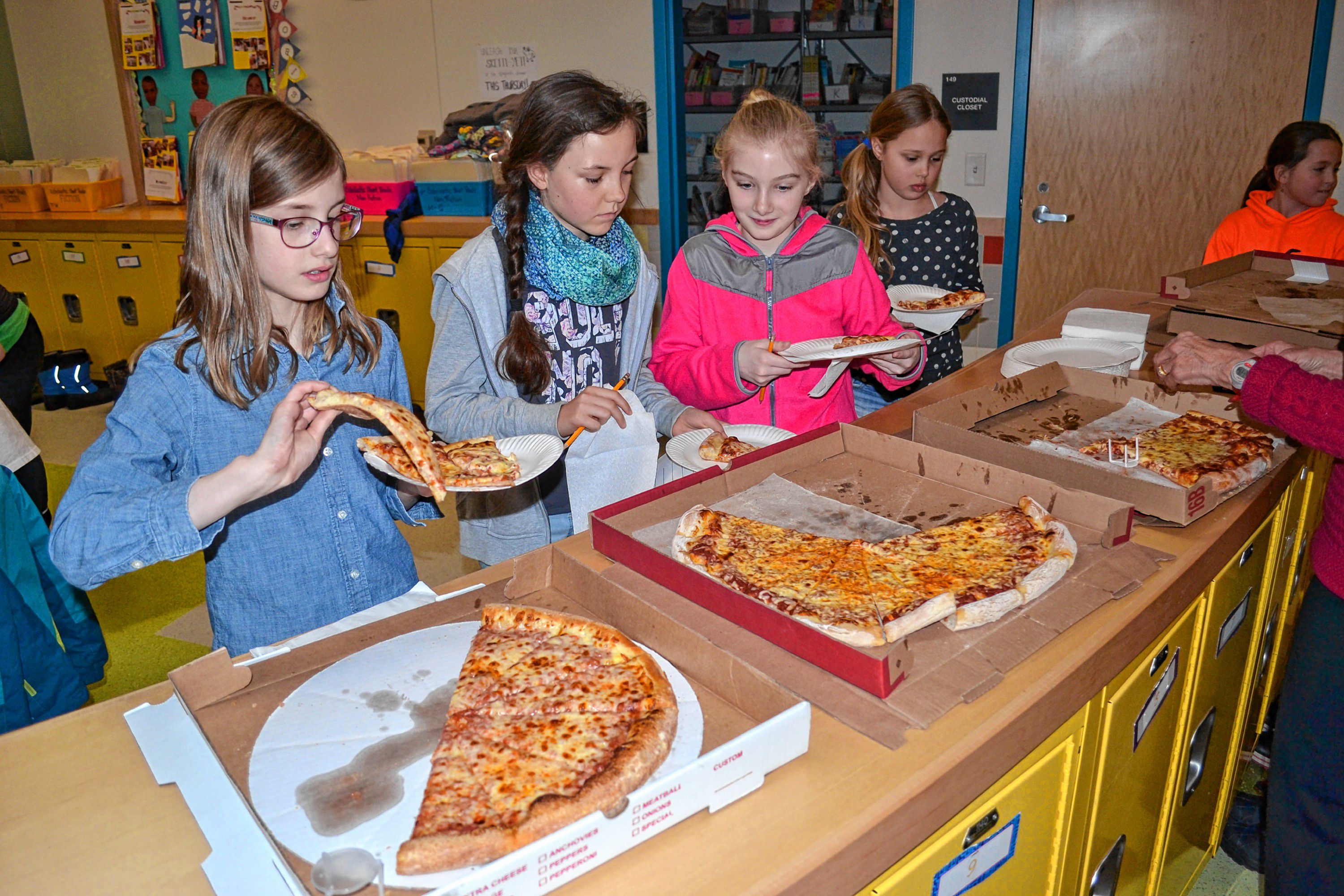 Christa McAuliffe student council members Ella Brisette, Malia Moffett,  Kenadee Couger and Mahalie Burdette grab slices of pizza from Constantly Pizza, Vinnie's Pizzaria and Sal's Pizza during a blind taste-test at the school last week. TIM GOODWIN / Insider staff