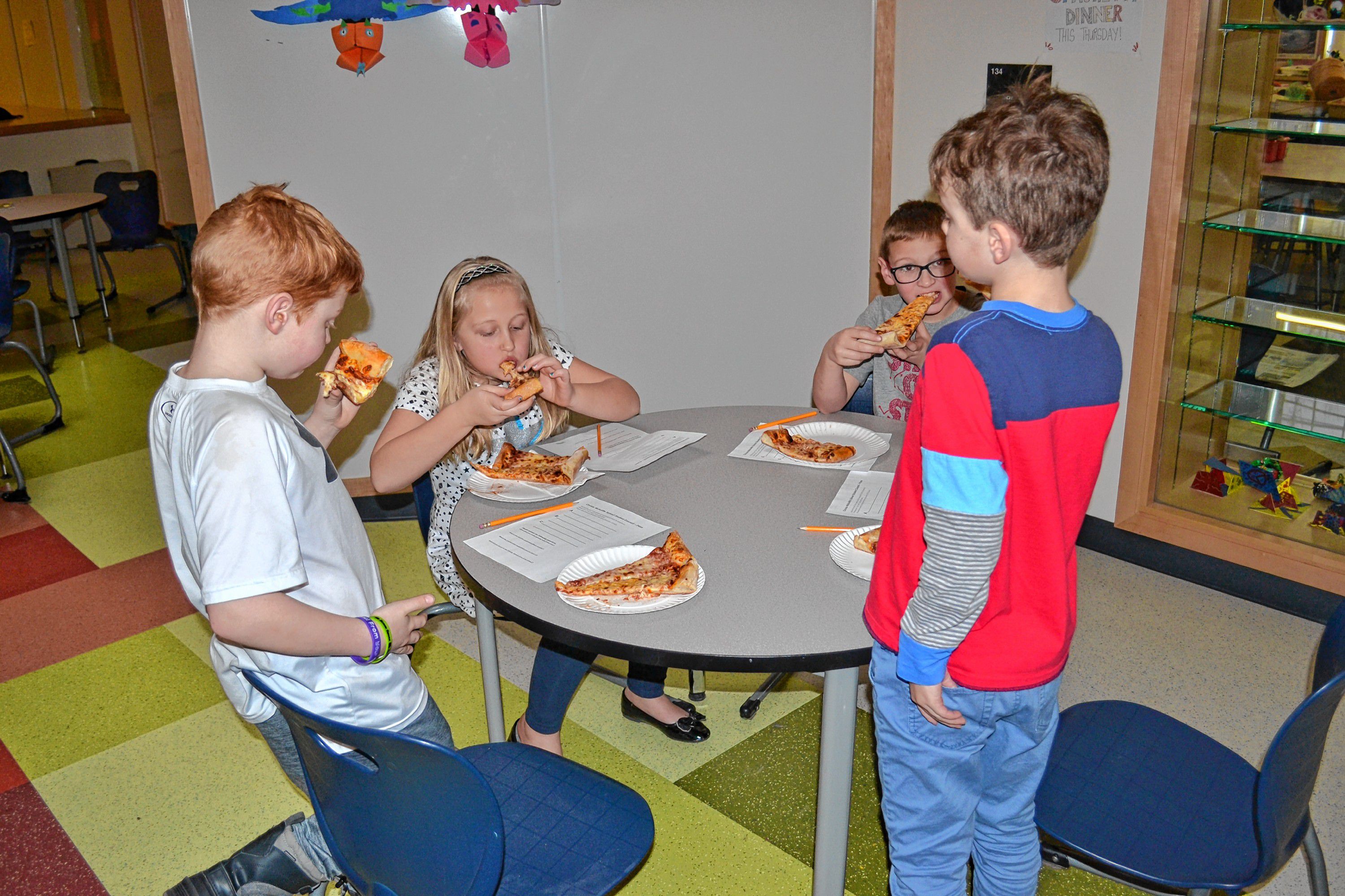 Will Bailey, Lilla Marston, Logan Sullivan and Colin  Smith enjoy a few slices of pizza during a blind taste-test at Christa McAuliffe School last week. TIM GOODWIN / Insider staff