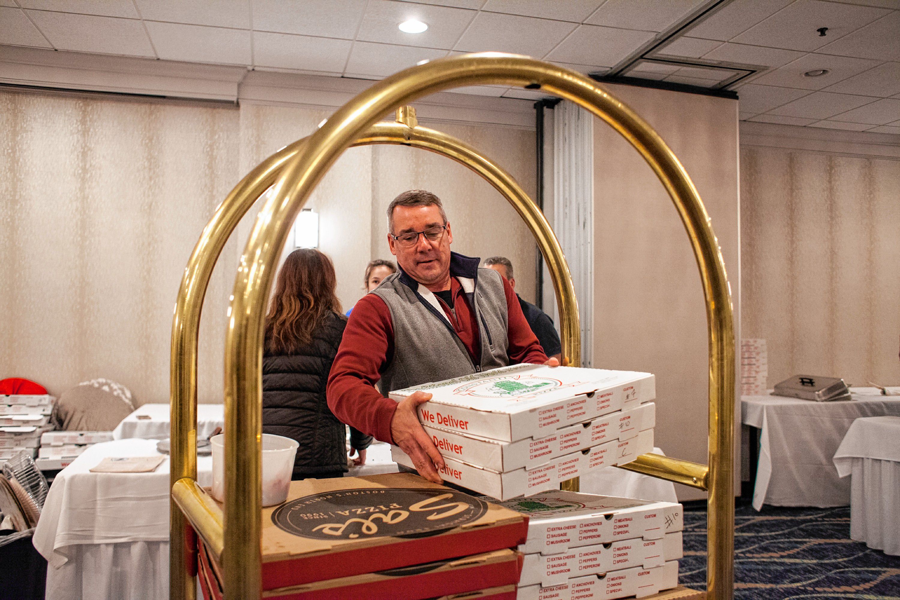 Friendly Kitchen coordinator Troy Burke gathers donated pizzas at the end of the Pizza Pie Showdown at the Holiday Inn in downtown Concord on Pi Day, Mar. 14, 2018. Proceeds from the event, hosted by the Concord Monitor and Insider, went to support the Friendly Kitchen. (ELIZABETH FRANTZ / Monitor staff) Elizabeth Frantz