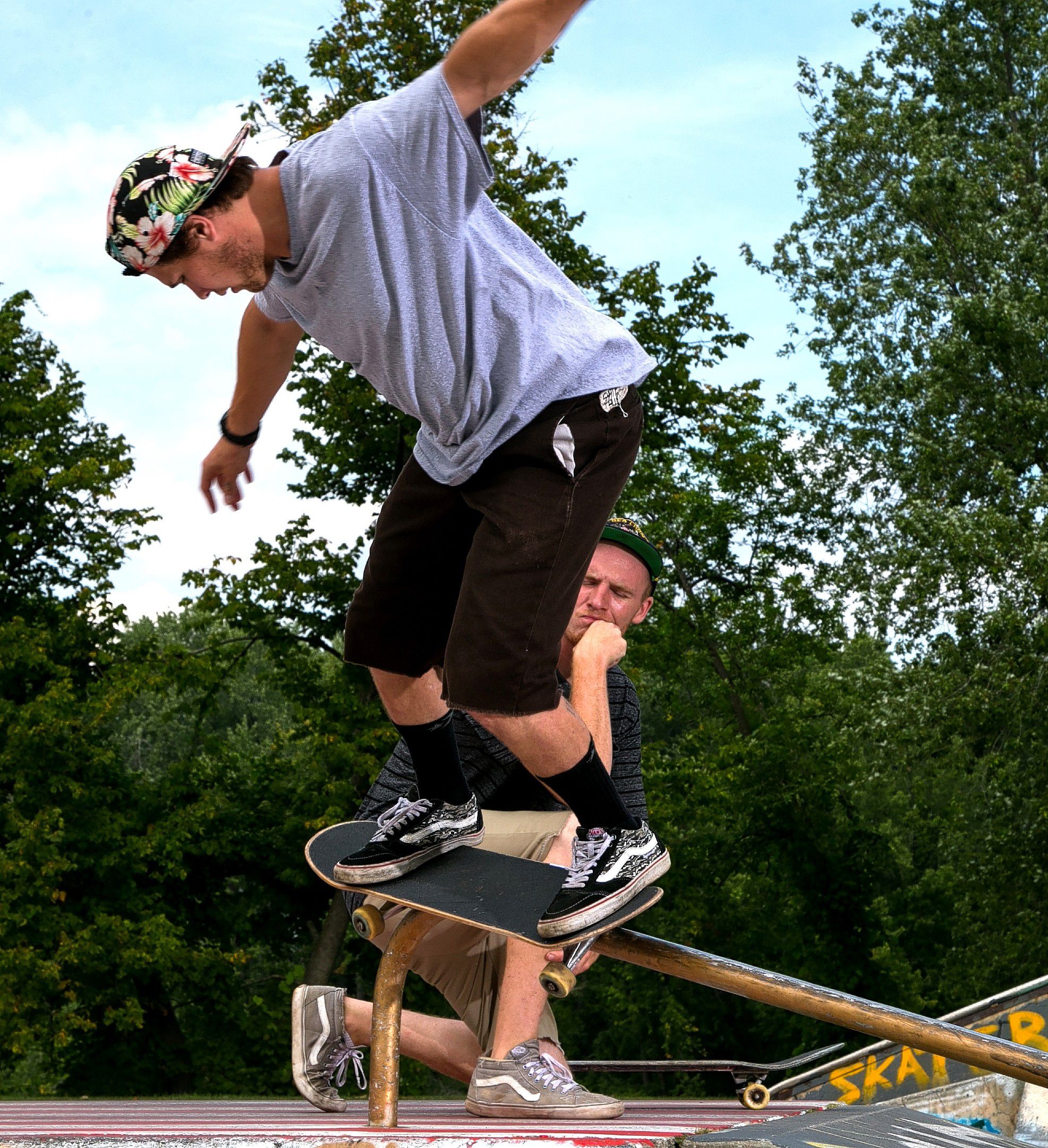 Scott Lamson of Concord watches as Tyler Castrogiovanni works the rail at the skateboarding park on Loudon Road this past week. A goup of friends spent the afternoon working their moves at the park behind Everitt Arena.  (GEOFF FORESTER / Monitor staff) GEOFF FORESTER