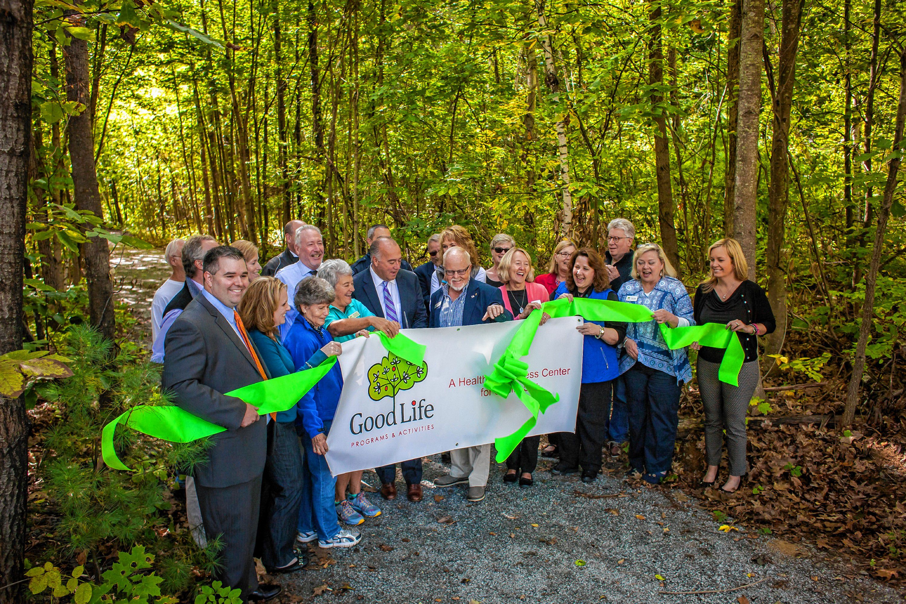 Mayor Jim Bouley makes the cut during the ribbon cutting ceremony at Smokestack Center in Concord on Oct. 6, 2016. Owners of Smokestack and their tenants, such as GoodLife Programs & Activities, hope the short trail is only the start of a larger vision for the wooded area off the centerâs parking lot. (ELIZABETH FRANTZ / Monitor staff) ELIZABETH FRANTZ