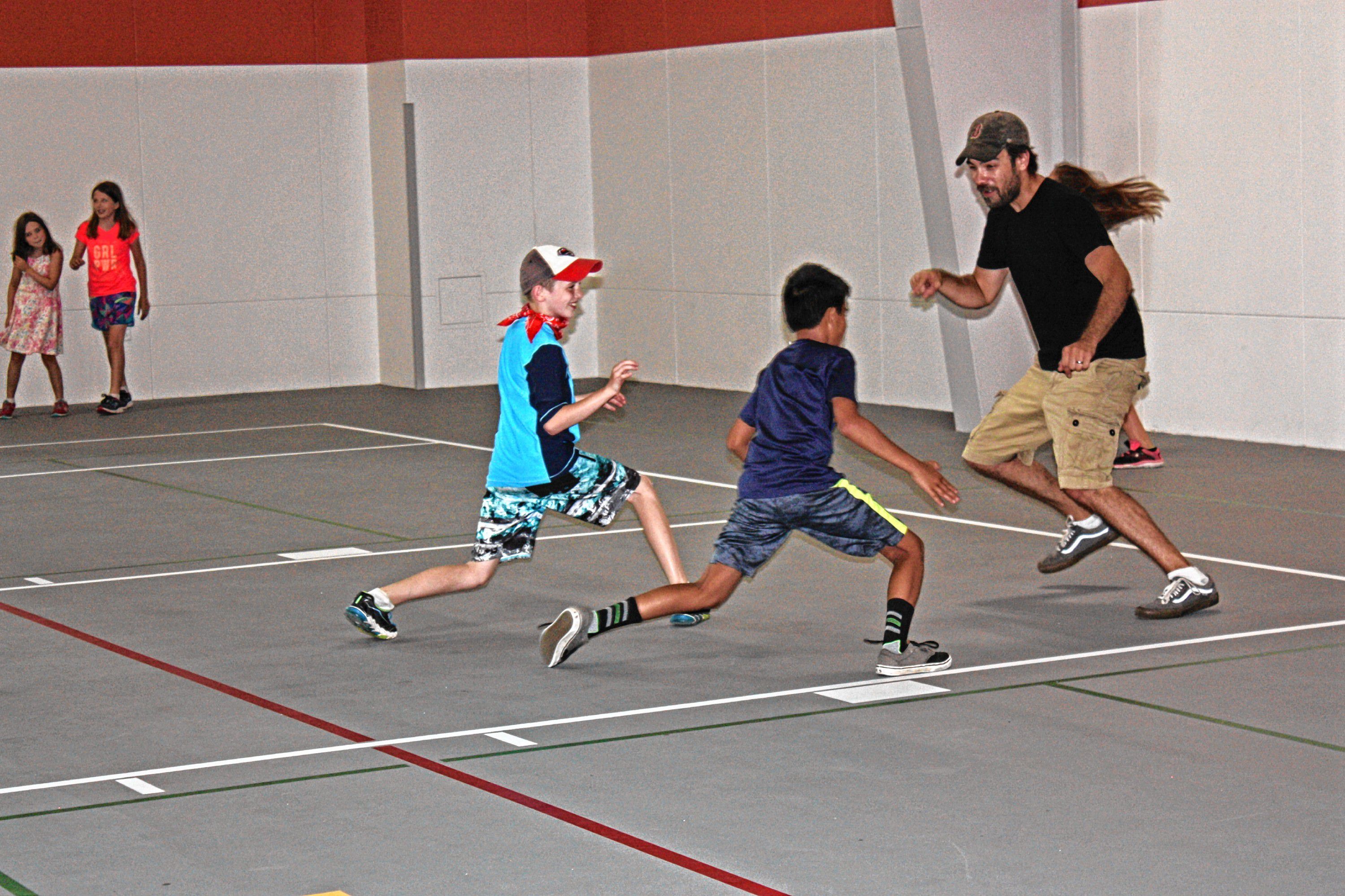 Jon gets schooled in a game of everybody's it tag with campers at the new City Wide Community Center last week. Who knew little kids could be so fast and nimble? OLIVIA HARDING / For the Insider