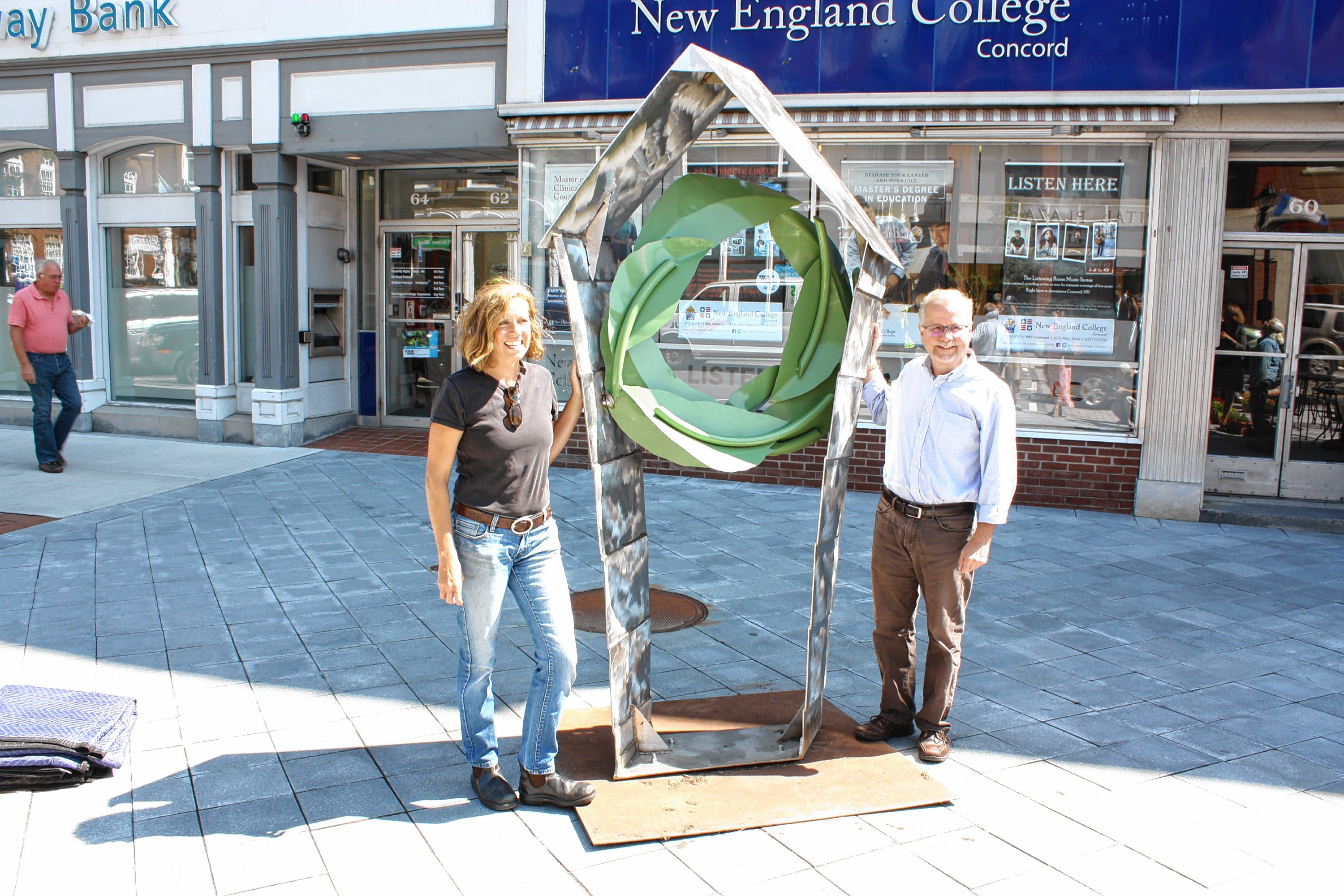 Boston artist Gillian Christy and Greater Concord Chamber of Commerce President Tim Sink pose for a photo beside Christy's sculpture "The Space Within" in front of NEC Concord on North Main Street after installing it on the sidewalk last Thursday. JON BODELL / Insider staff