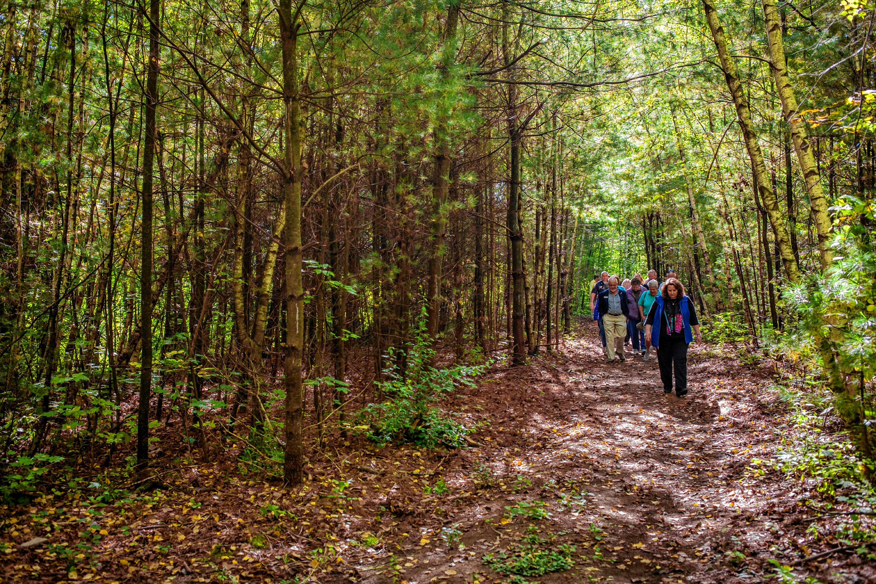 Community members walk along a new public trail following a ribbon cutting ceremony at Smokestack Center in Concord on Oct. 6, 2016. Owners of Smokestack and their tenants, such as GoodLife Programs & Activities, hope the short trail is only the start of a larger vision for the wooded area off the centerâs parking lot. (ELIZABETH FRANTZ / Monitor staff) ELIZABETH FRANTZ