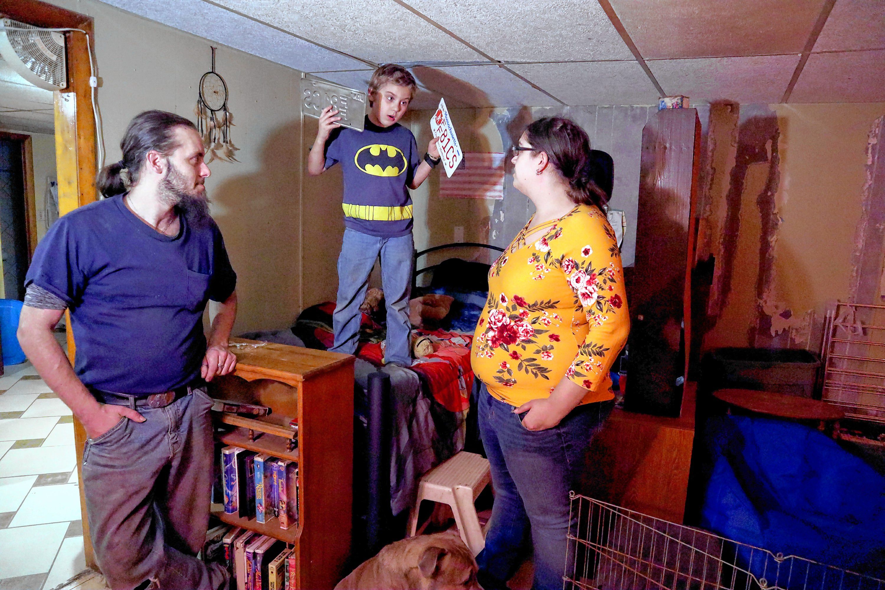 Shaye Campbell, 9, shows his excitement when he has an idea to decorate the walls of his new room with old license plates. Campbell was living in a tent back in September after his family’s apartment was lost in an accidental fire.