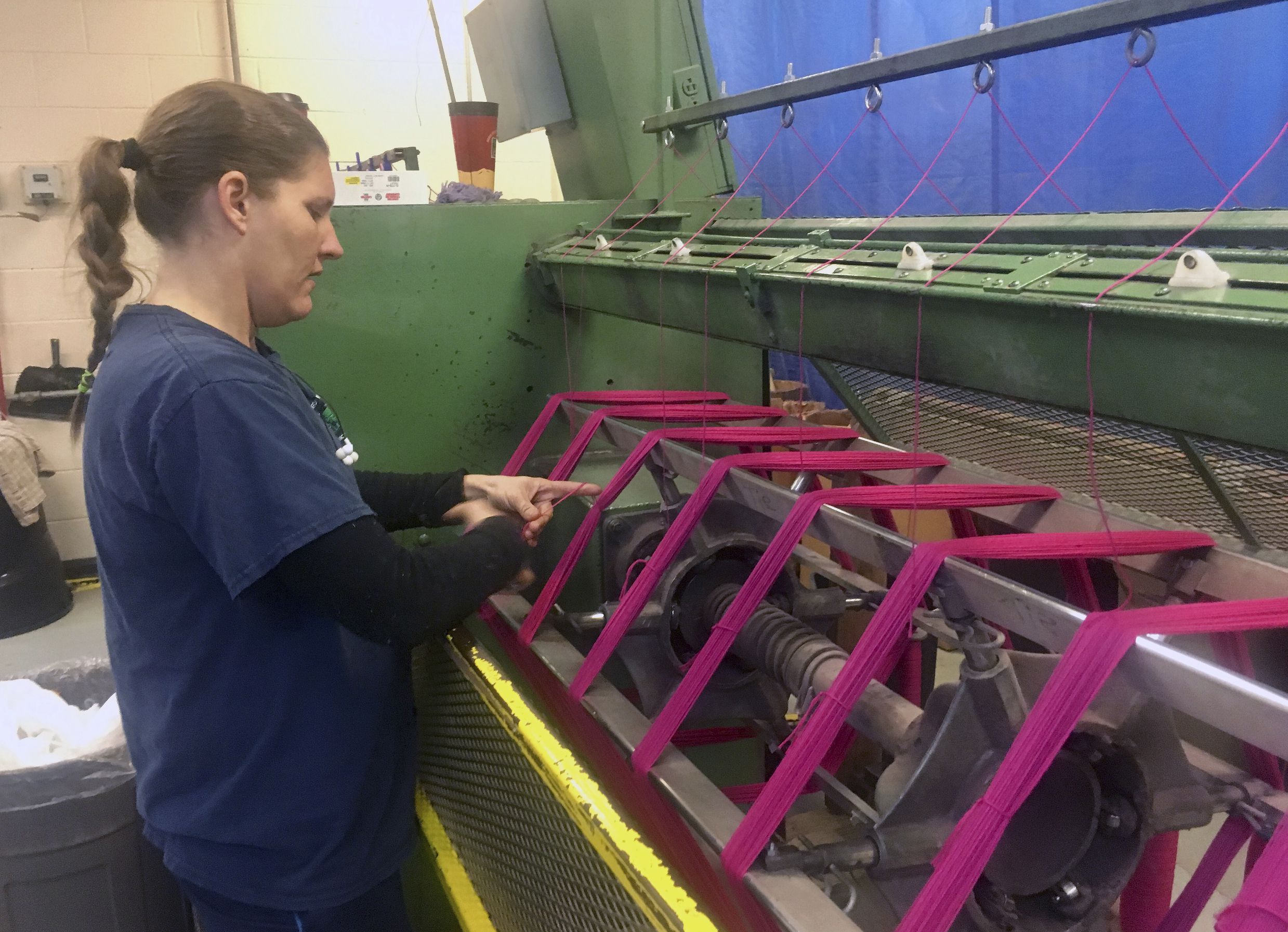 This Oct. 16, 2018 photo shows Debbie McDermott's daughter, Jamie Sparks, tying freshly-spun yarn into skeins. Sparks' raising of two sheep for a 4-H project inspired her mother to establish Stonehedge Fiber Mill in East Jordan, Mich., on the family's 165-year-old farm in 1999. (Shireen Korkzan via AP)  Shireen Korkzan