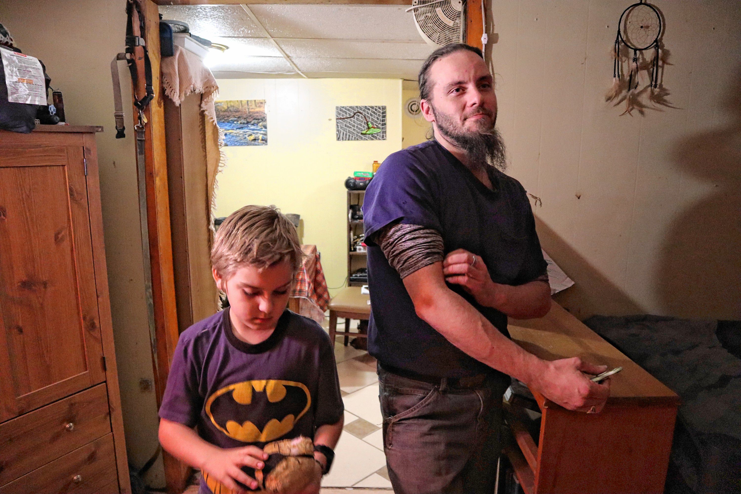 Shaye Campbell, 9, walks by his father holding a stuffed animal in their new apartment in Chichester. 