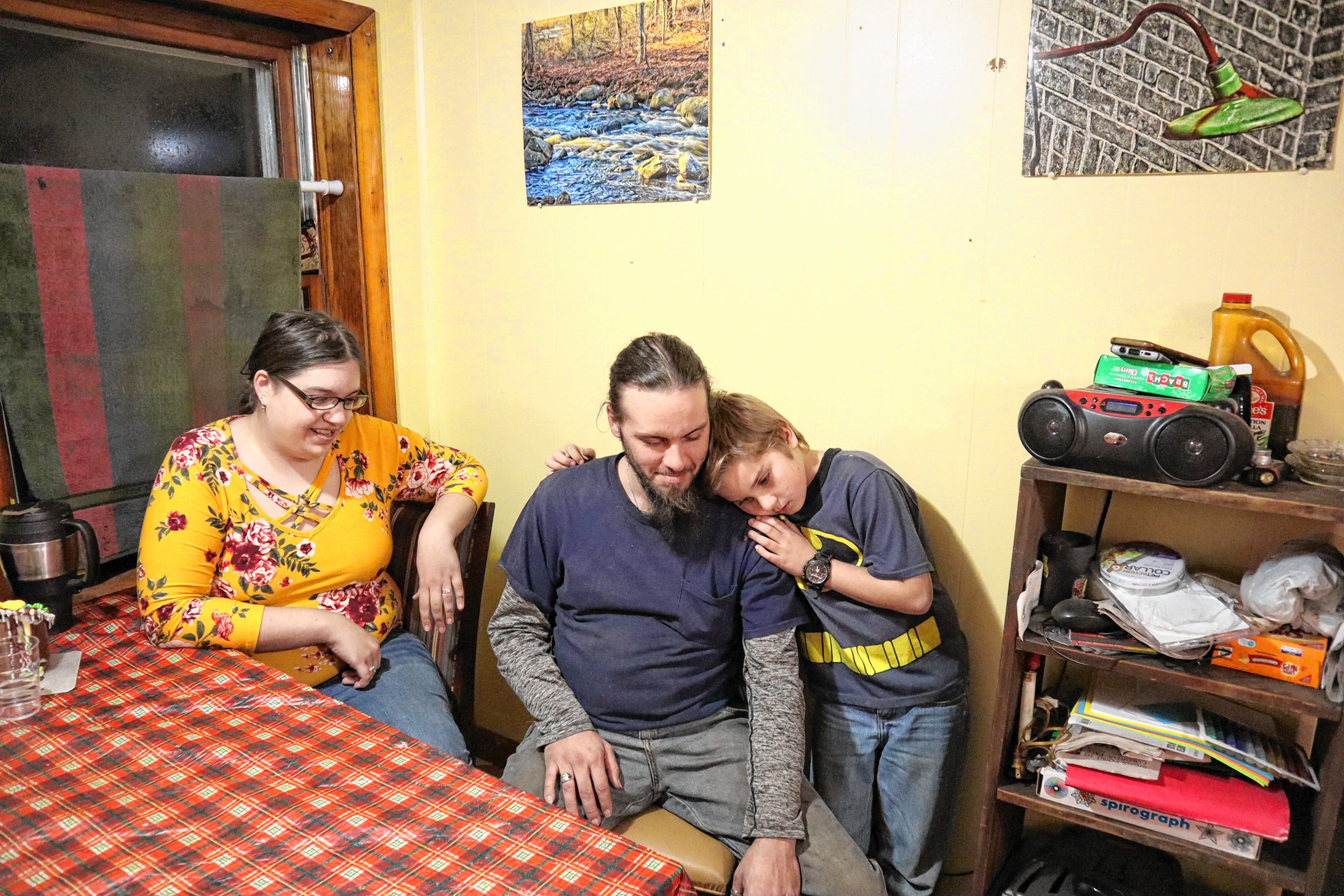 Vicki Cobb and Mark Aucoin hug Aucoin’s son Shaye at their apartment in Chichester last Wednesday. 