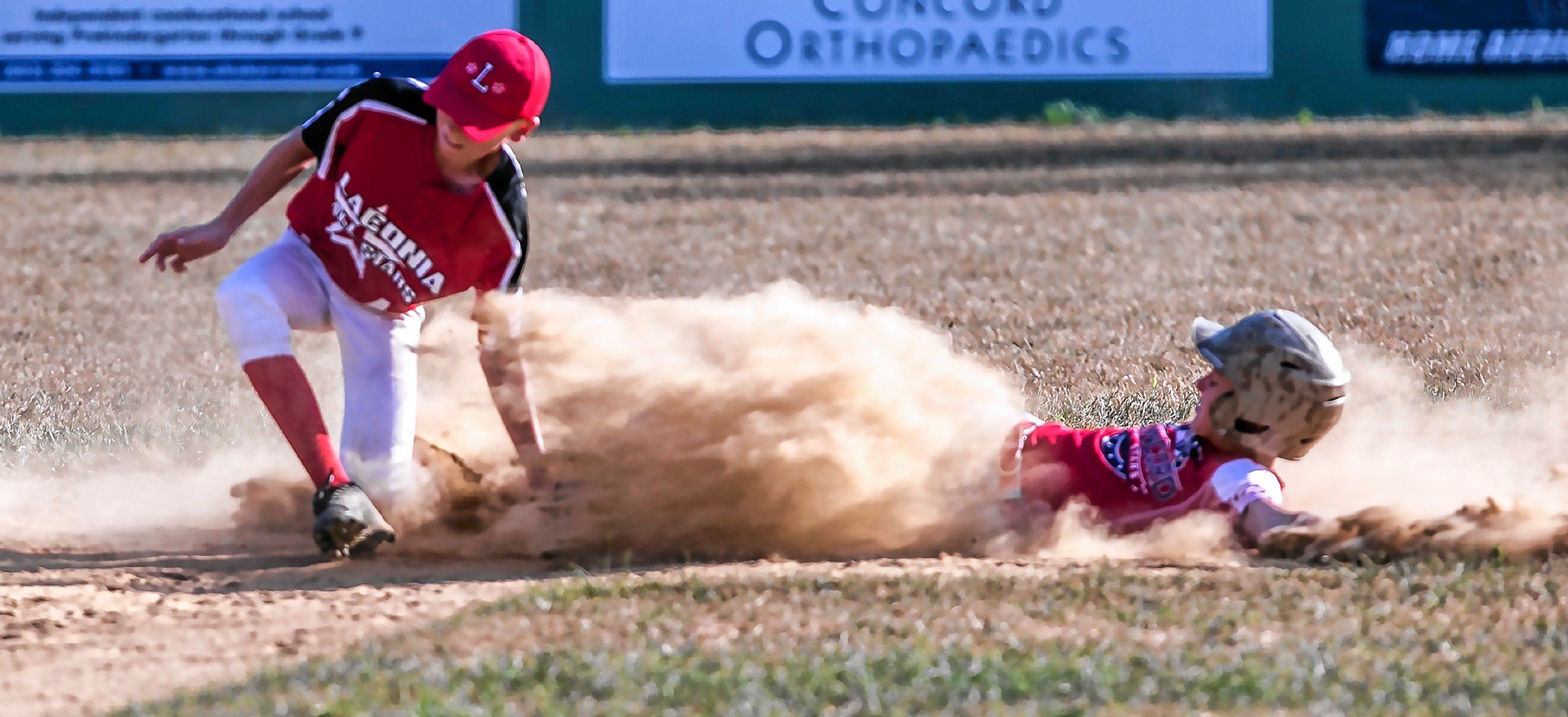 Concord Little League All-Star Nick Reynolds slides in safely as Laconia shortstop Ben Beaudoin tries to apply the tag in the second inning at Grappone Park in Concord on Friday, July 13, 2108. GEOFF FORESTER