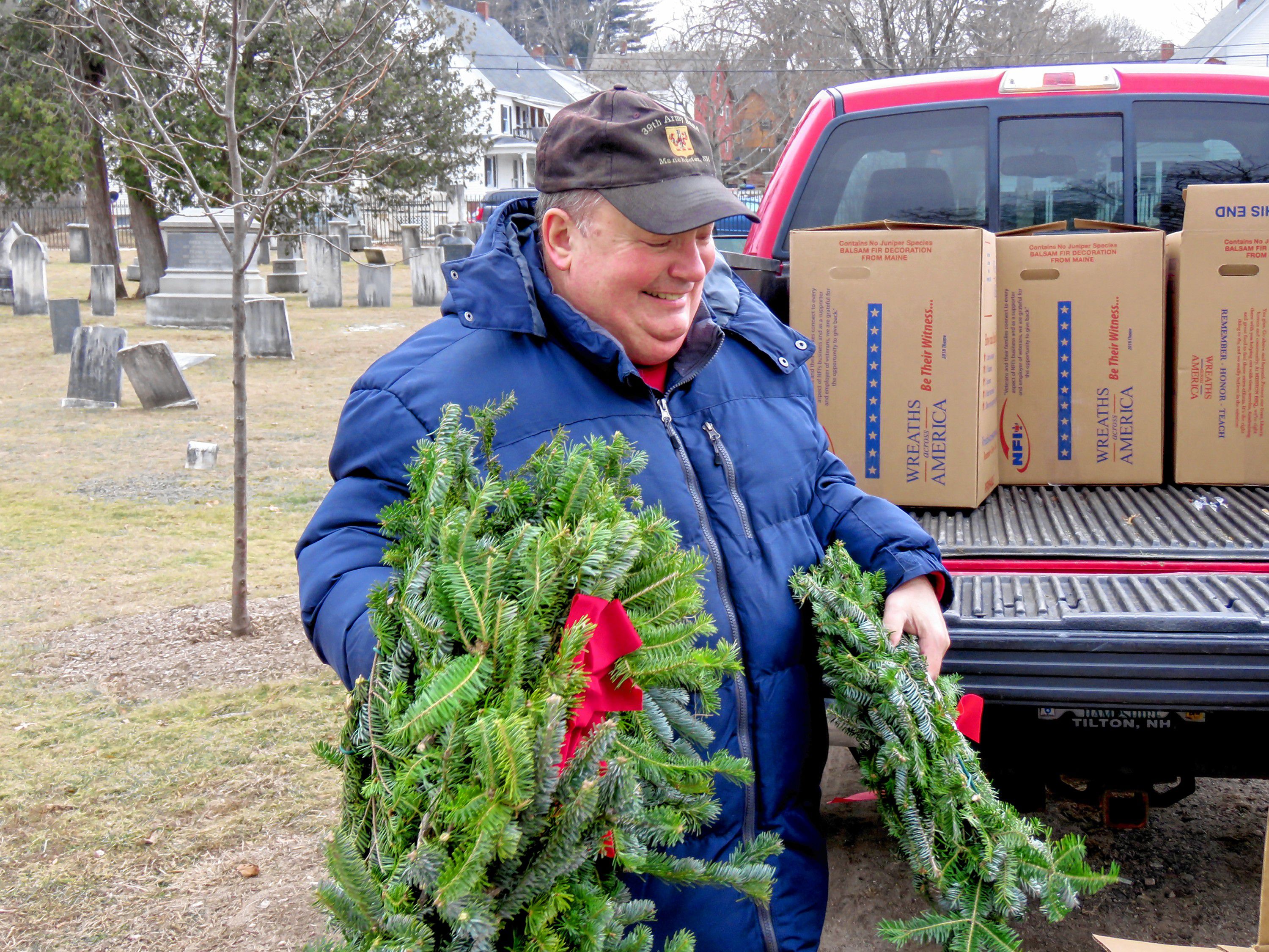 Pierce Brigade member Tom Fisk gathers up wreaths to put on veterans' graves in the Old North Cemetery in Concord on Friday. Caitlin Andrews