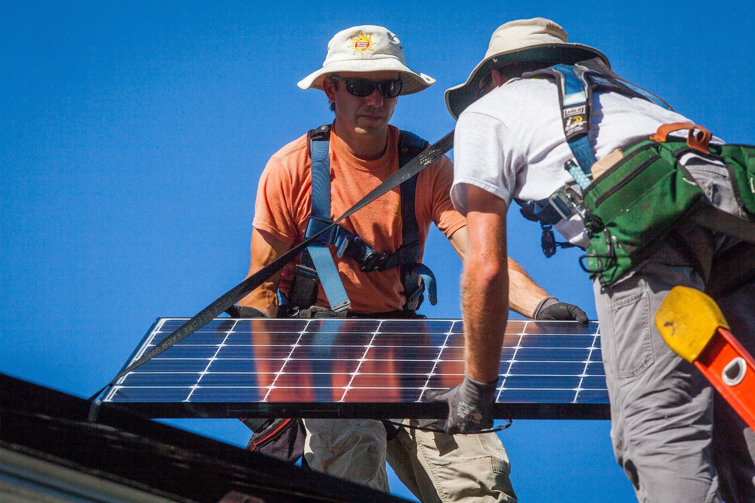 ReVision Energy employees Steve Dzubak (left) and Jared Cobb install a solar panel on the roof of a Concord home on Thursday, Aug. 27, 2015. In total, 25 panels will be installed and will supply the homeowner with more power than he is expected to use. (ELIZABETH FRANTZ / Monitor staff) 