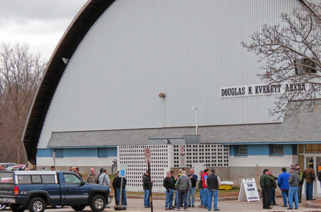 A line of people wait outside the Douglas N. Everett Arena to get into an event. 