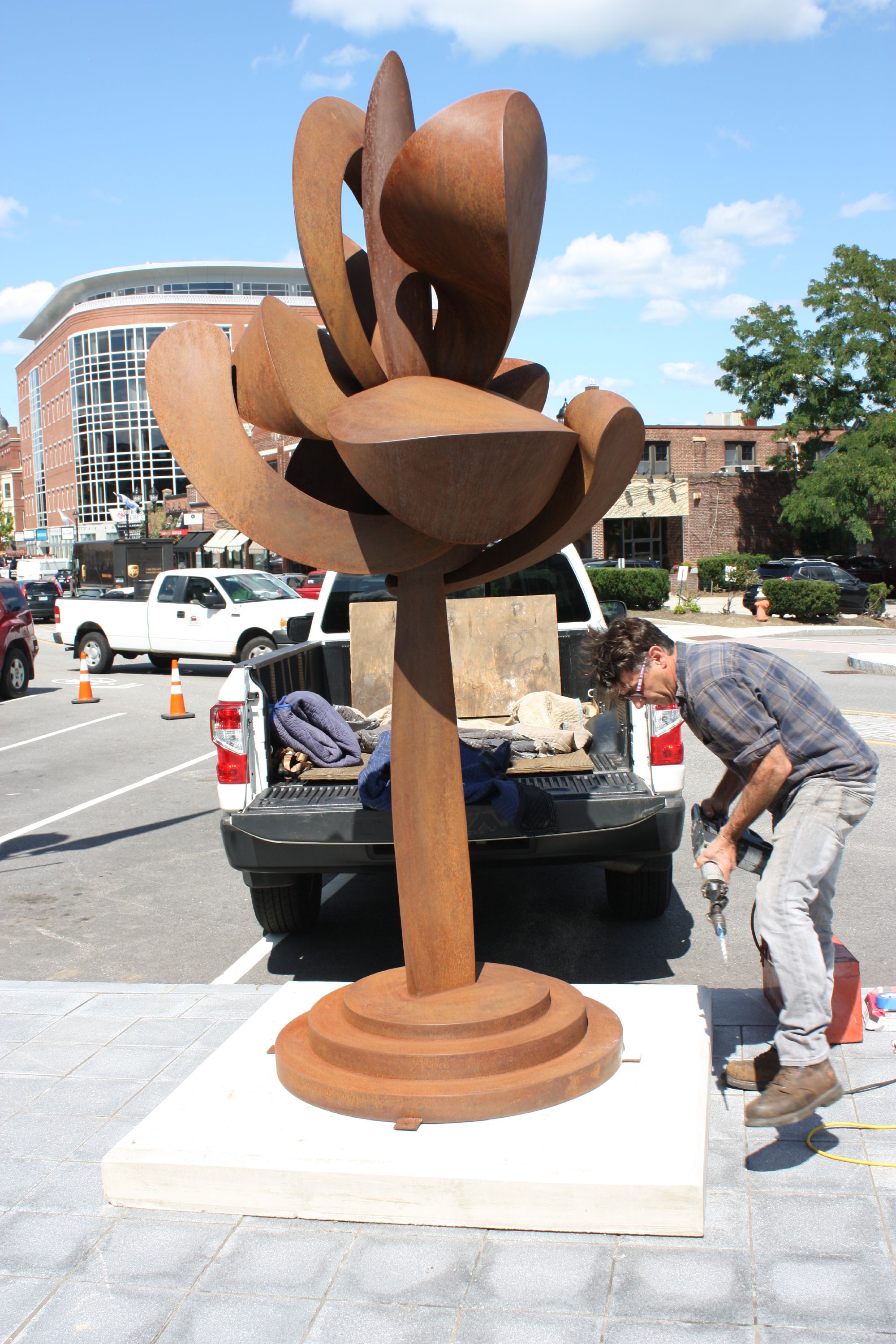 Artist David Boyajian of New Fairfield, Conn., works to install his sculpture "Unfurling With Seeds" at the intersection of South Main and Fayette streets last Thursday, a day in which two big sculptures were installed as public art in downtown Concord. JON BODELL / Insider staff