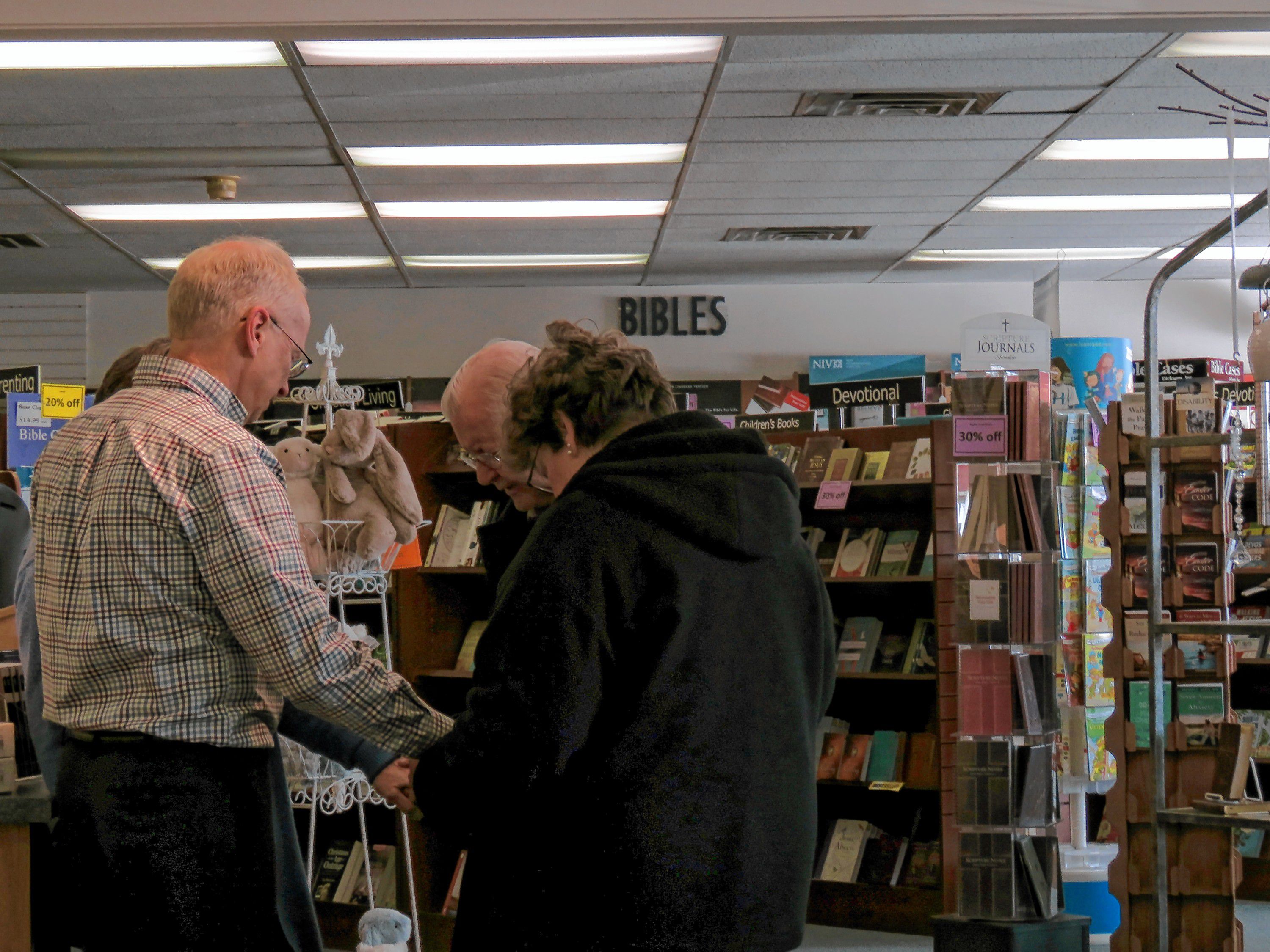 Mark Cheeseman and his wife Jane (left) pray with Rochester Church of God officials Patty Dyler and Wayne Nelson (right) at Parable Bible Bookstore in Concord on March 8, 2019. Nelson said he has been driving 35 miles periodically to visit the bookstore, which is closing at the end of this month. Caitlin Andrews