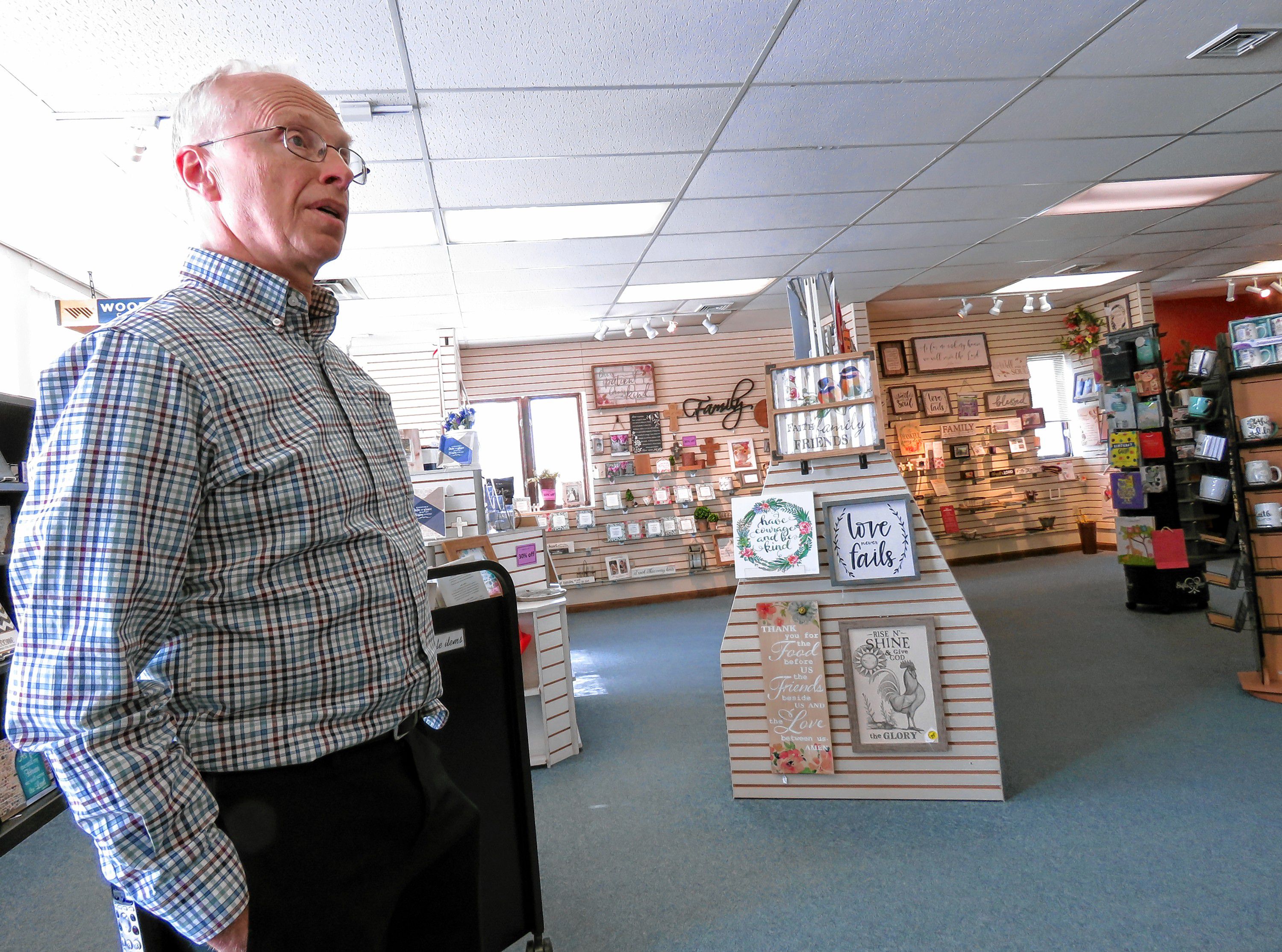 Mark Cheeseman describes some of the wares in his specialty bookstore, Parable Bible Bookstore, on March 9, 2019. The store is closing after 35 years in Concord.  Caitlin Andrews