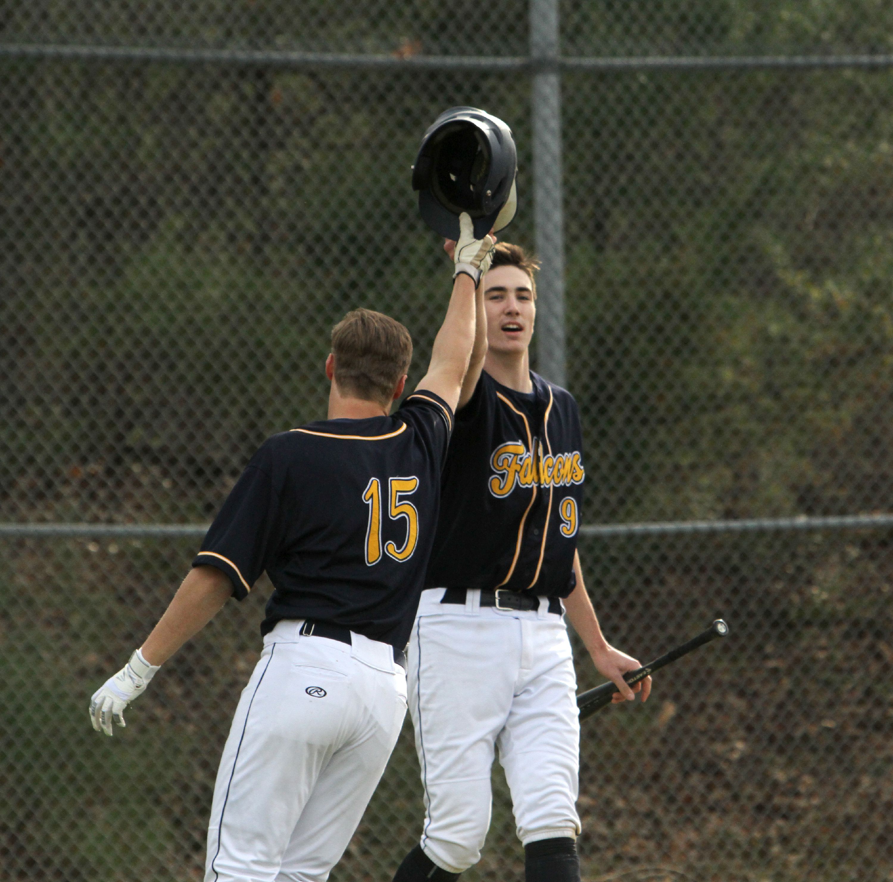Bow's Ben Harris (9) and Steven Guerrette (15) celebrate after scoring on a two-run single by Riley Elliott during a 9-5 win over Souhegan on Monday at Bow High School. Jason Orfao