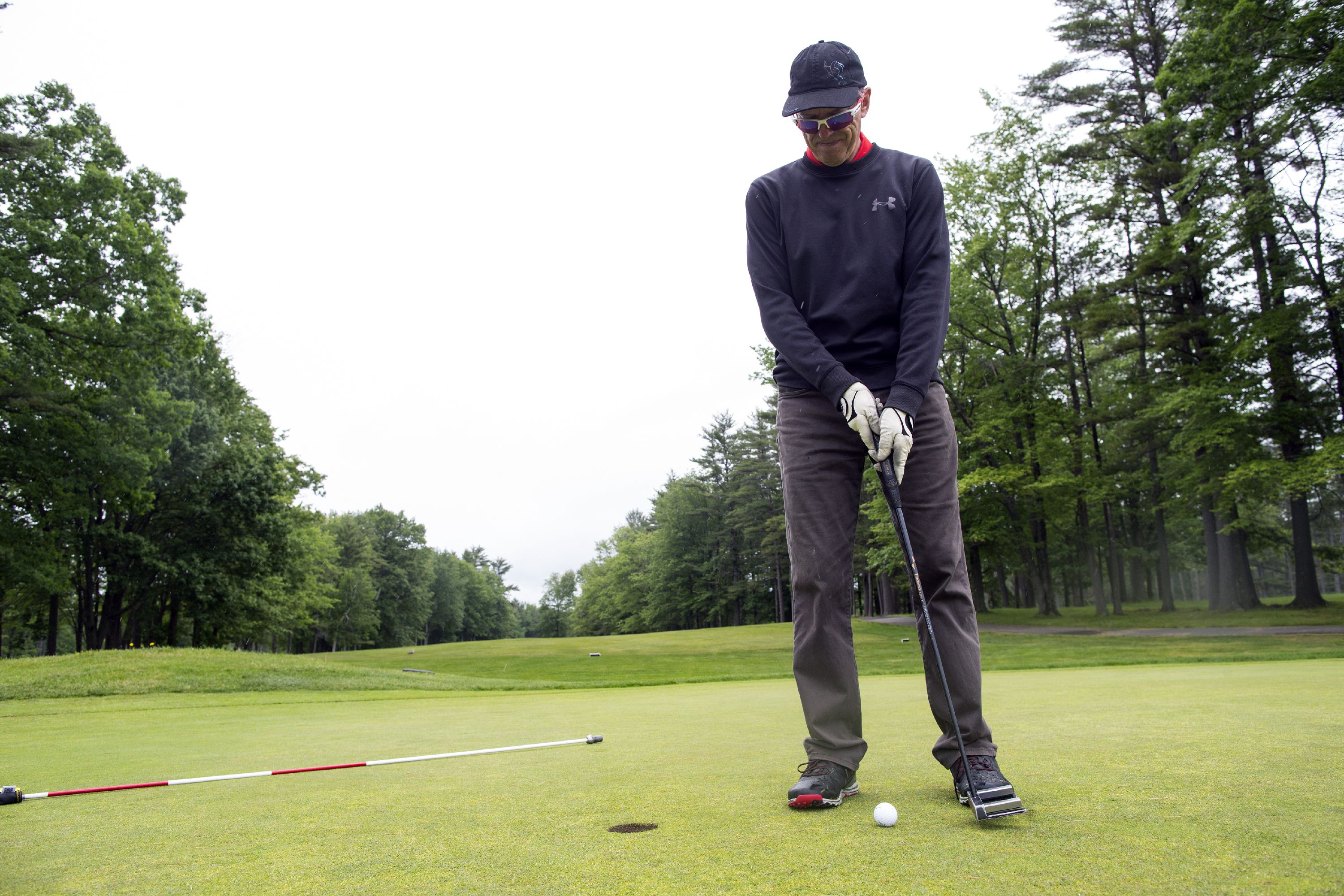 Ed Thompson of Bow taps in on the 9th hole of the Beaver Meadow Golf Course on Tuesday, May 5, 2018. Thompson played in spite of the rain. GEOFF FORESTER