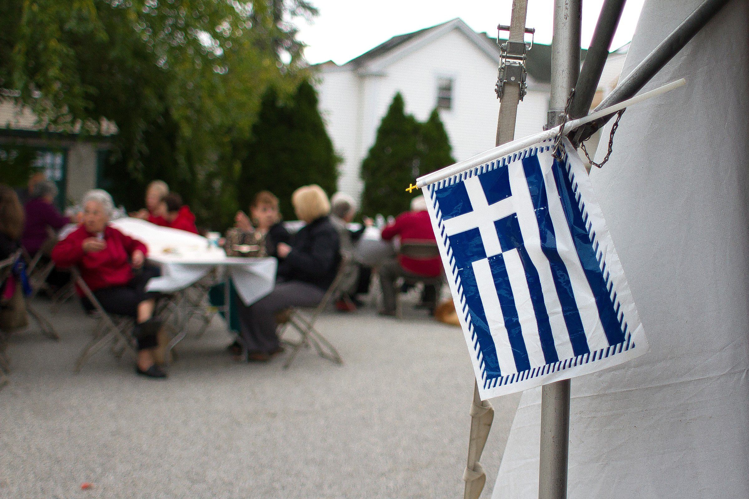 The Greek flag hangs off the side of a tent at the "A Taste of Greece" Greek festival at Holy Trinity Greek Orthodox Church in Concord on Saturday, Sept. 20, 2014. (JULIE BYRD-JENKINS / Monitor staff) Julie Byrd-Jenkins