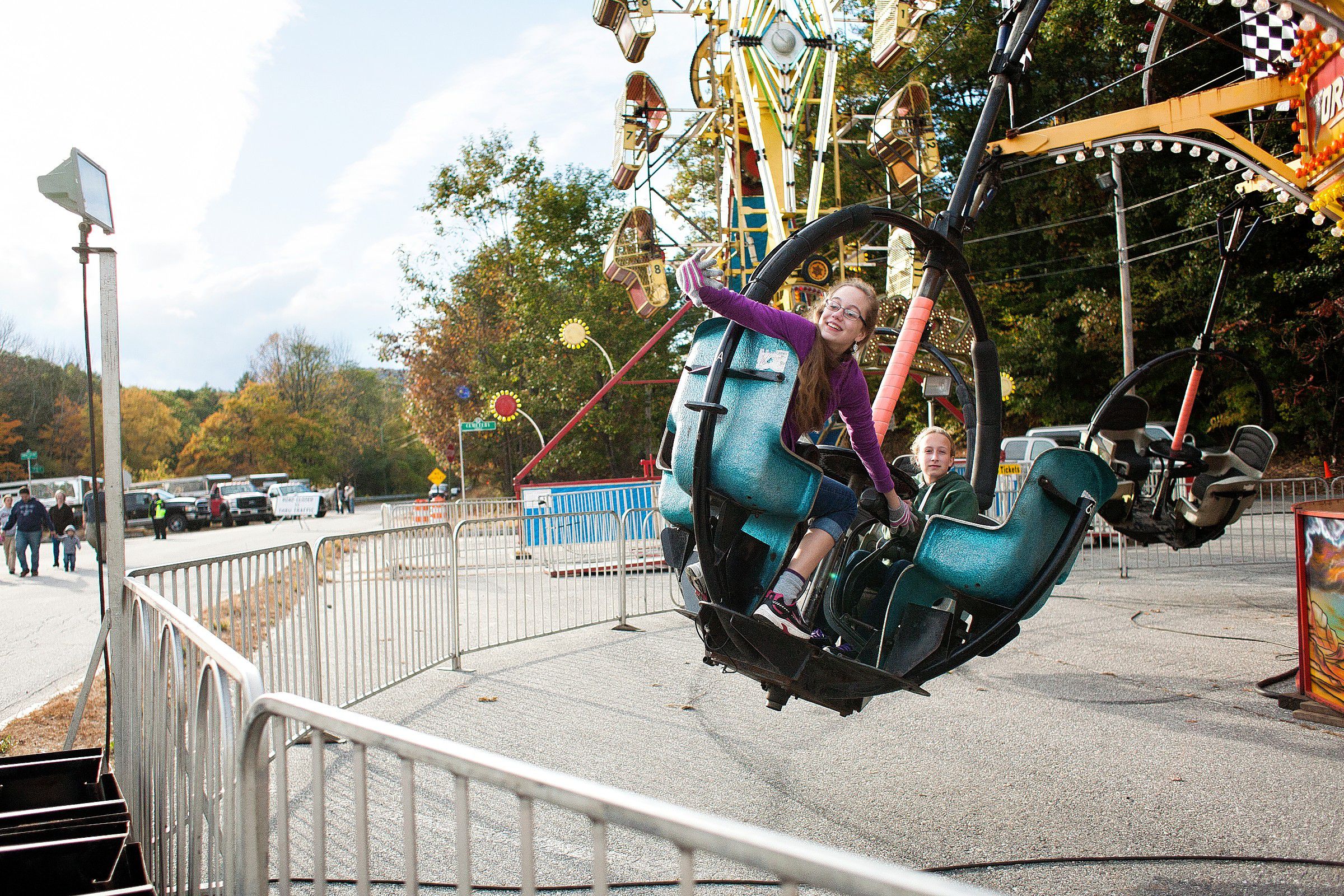 Sophia Harne, 13, of Warner waves as she spots a group of her friends while riding the Tornado ride in the Midway with her friend Cierra Mailloux, 14, of Hopkinton at the Warner Fall Foliage Festival on Saturday, Oct. 11, 2014.  (JULIE BYRD-JENKINS / Monitor staff) JULIE BYRD-JENKINS