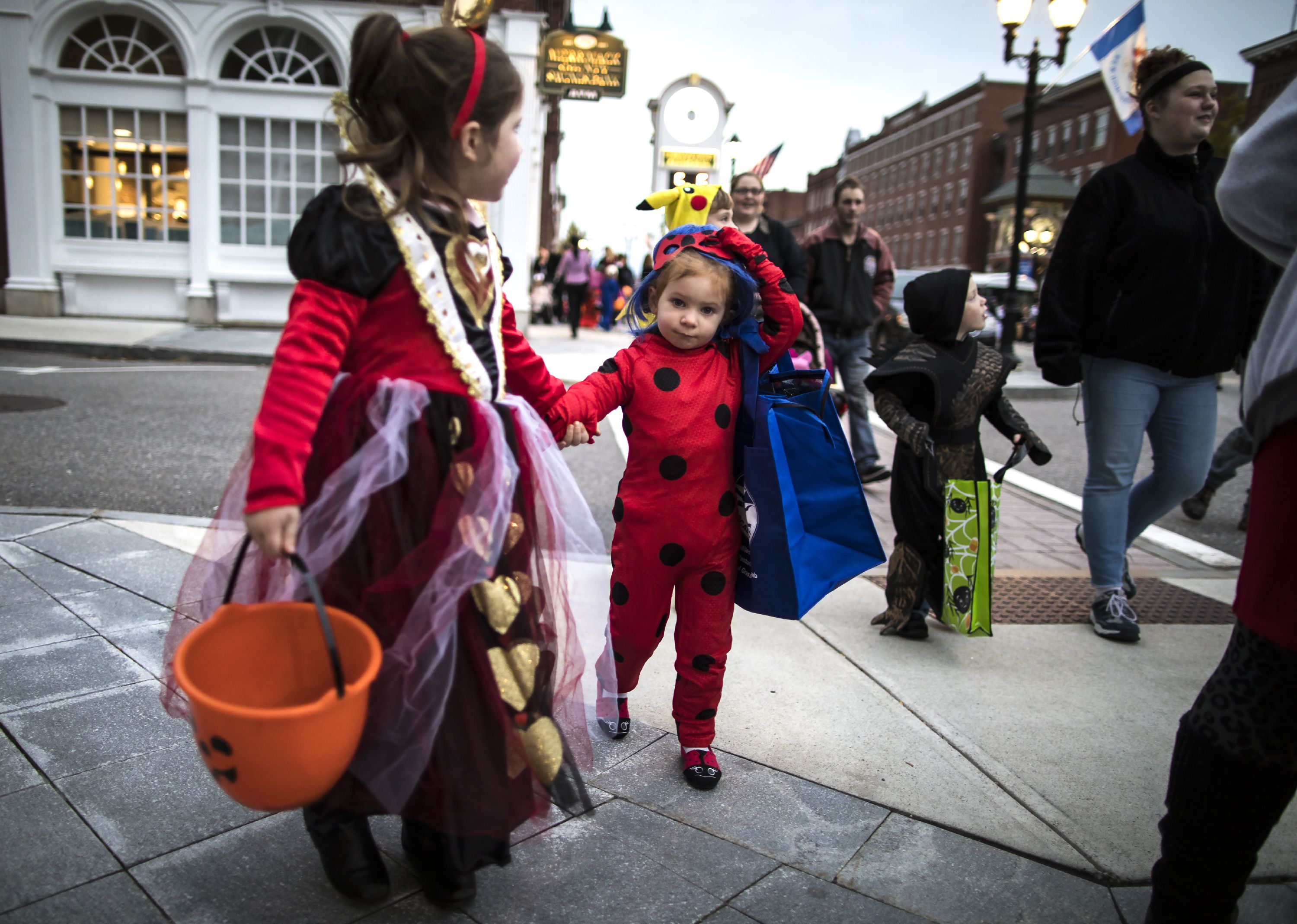 Morgan Hallee, 5, (left) and her cousin Aubree Cate, 3, of Manchester make their way down Main Street at the Halloween Howl on Friday evening, October 25, 2019. GEOFF FORESTER